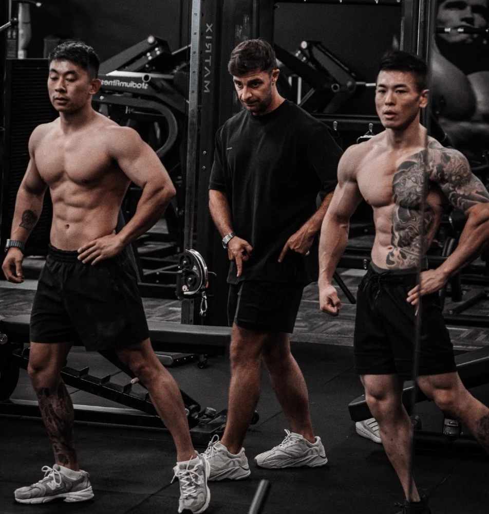 Oliver Vidler coaching two physique athletes during posing practice