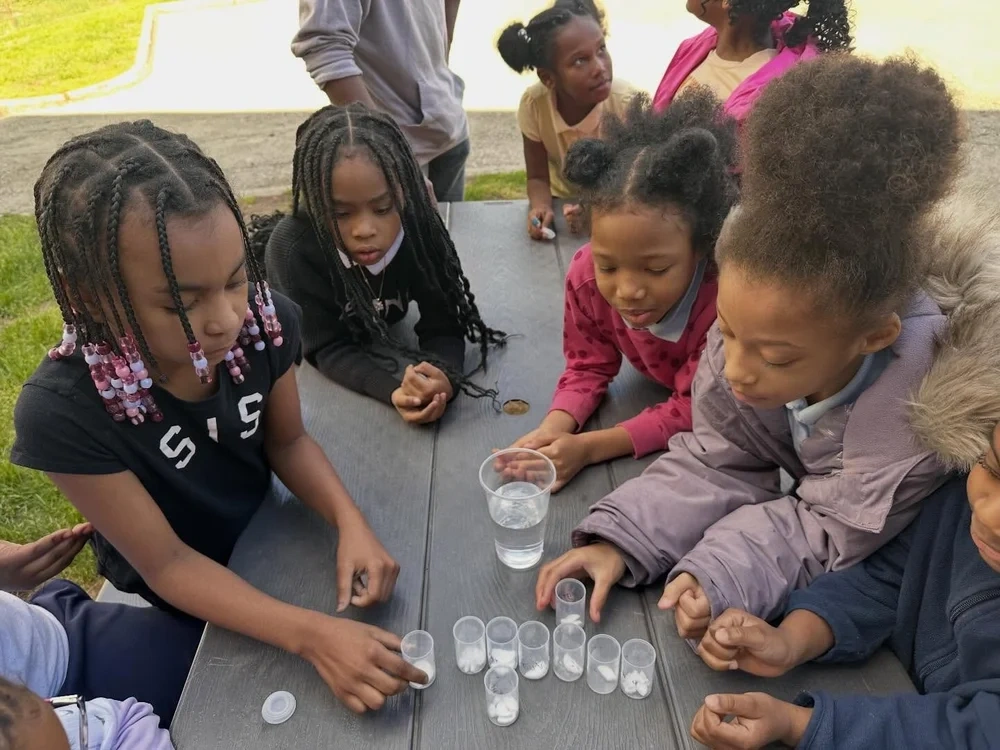 Girls gathered around a table for a shared learning activity