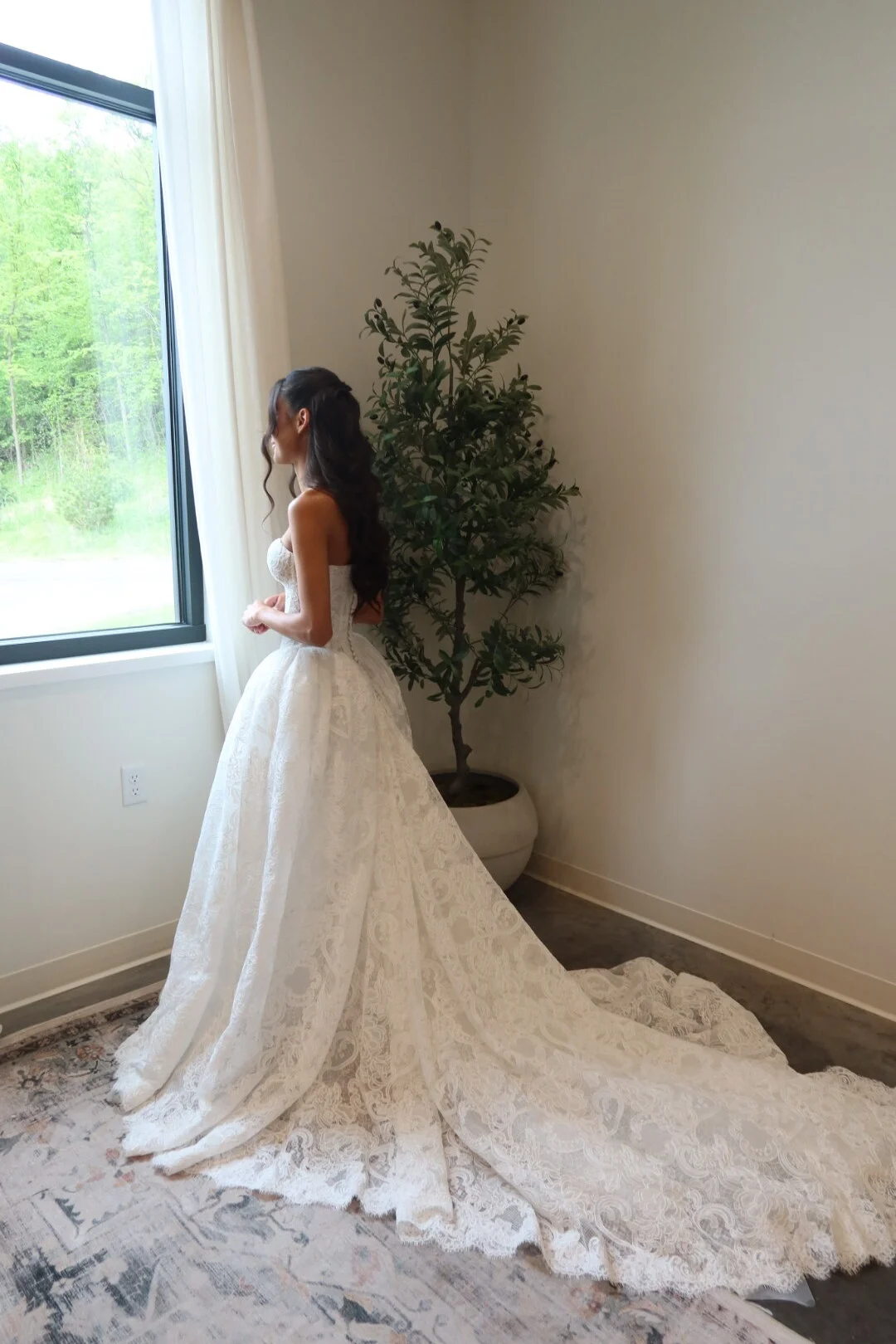 Bride photographed in profile beside a bright window