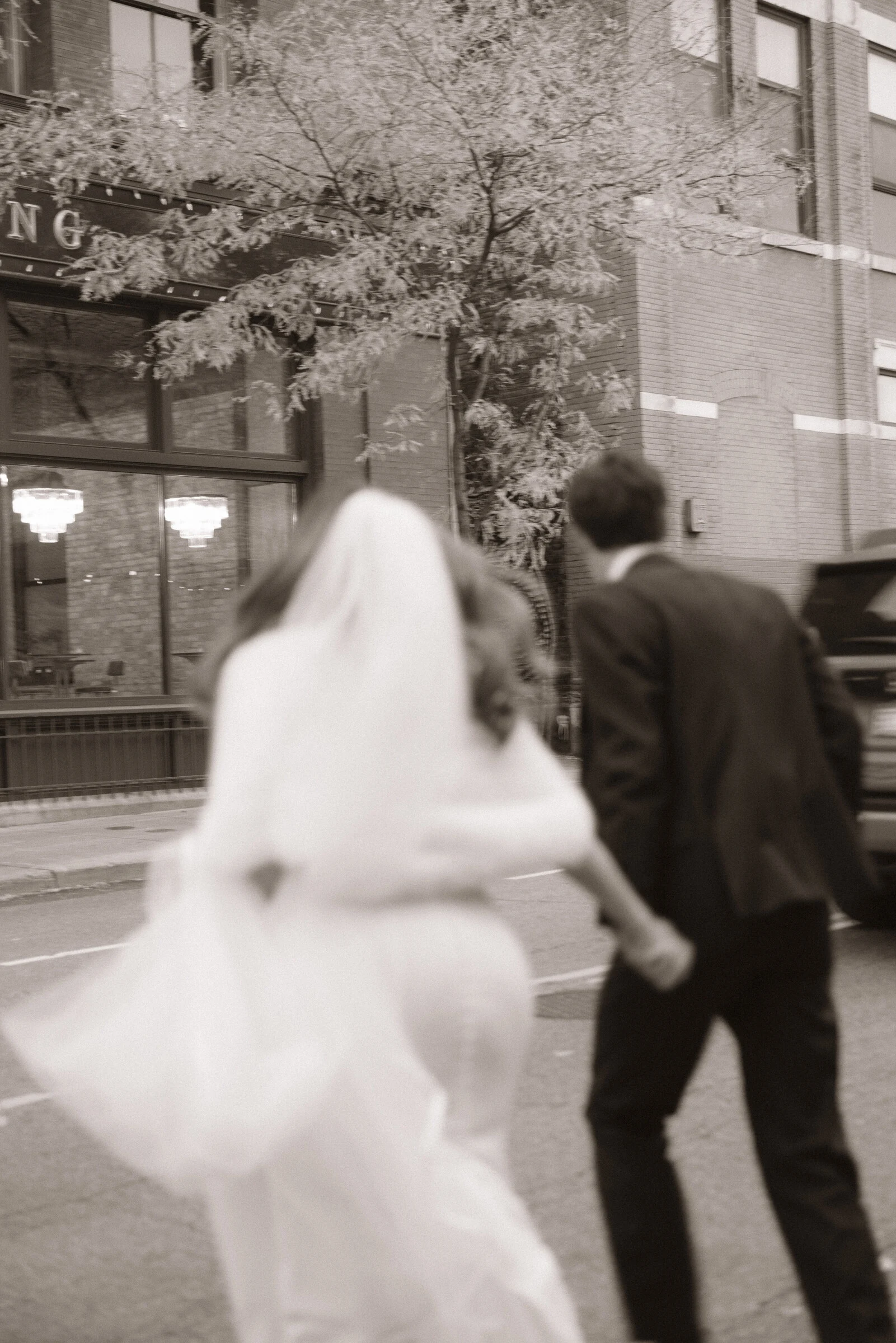 Black-and-white photograph of a couple walking through the city