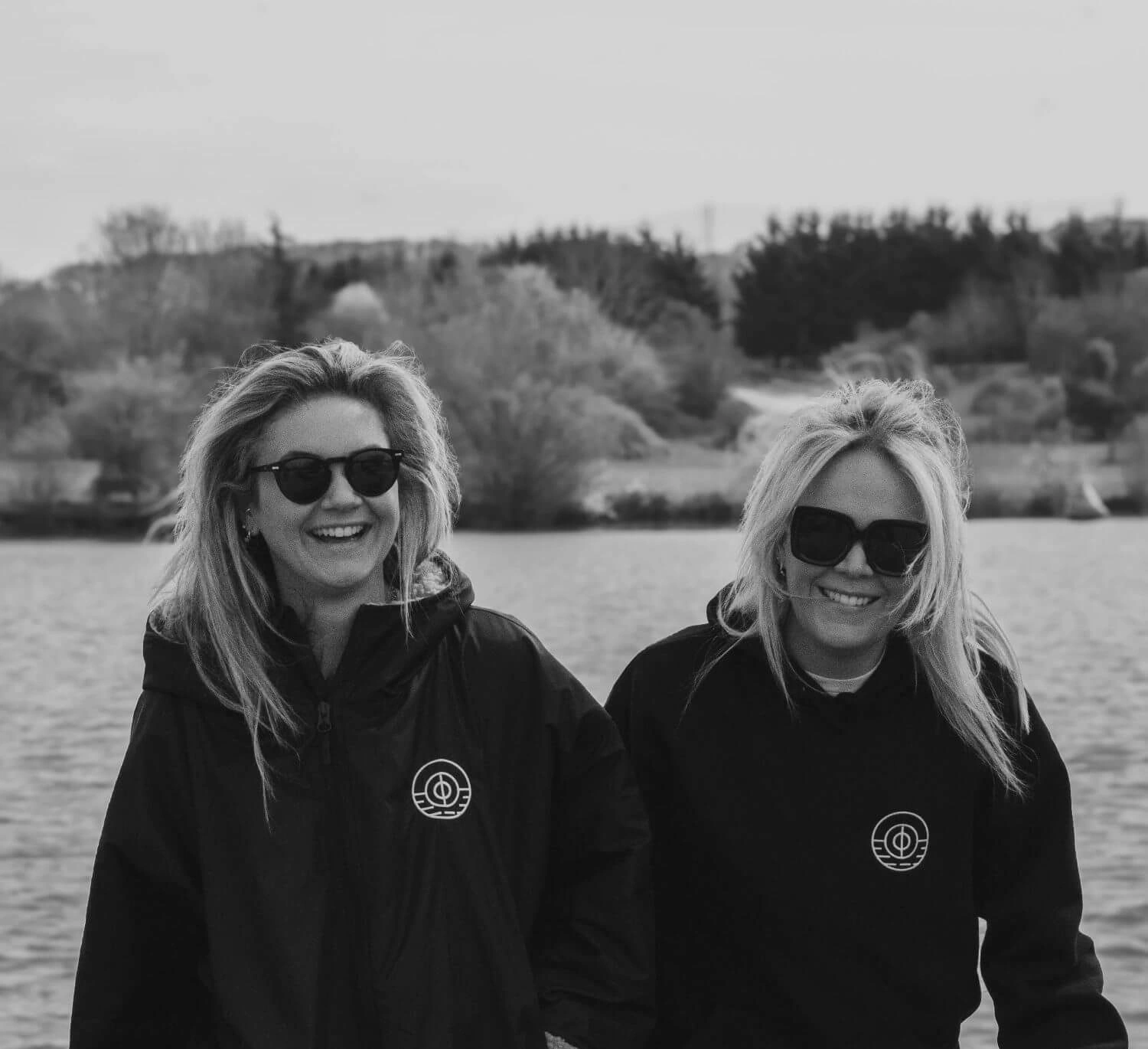 Founders Emily and Sophy smiling by the lake