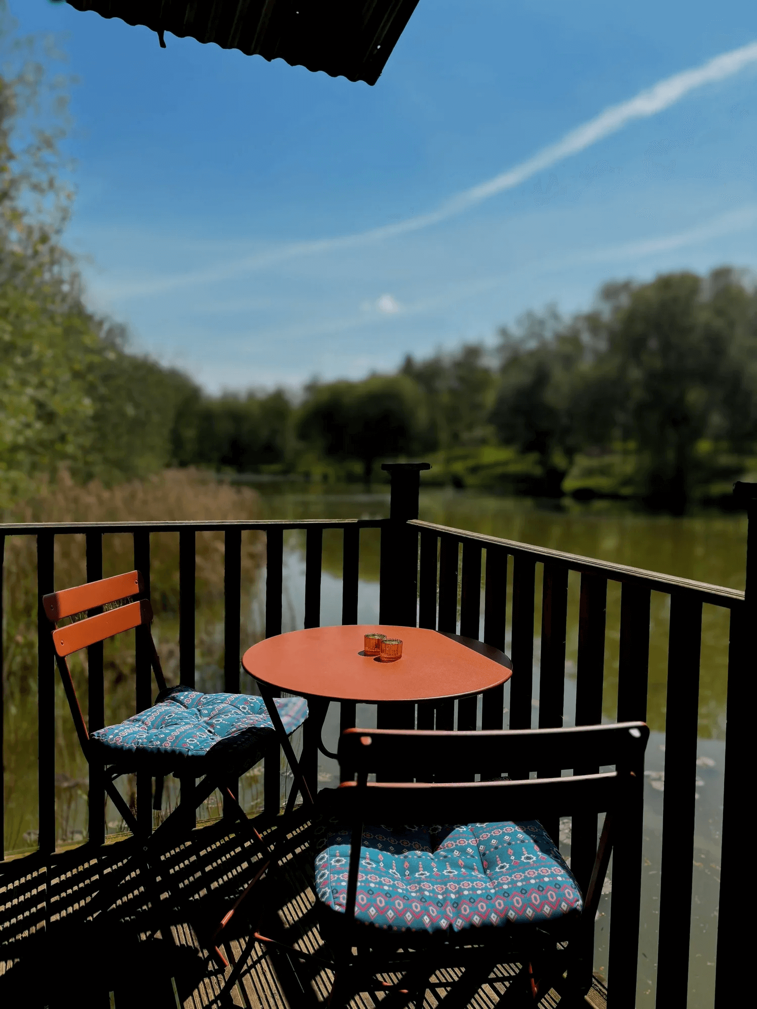 Balcony with a table and chairs overlooking the water