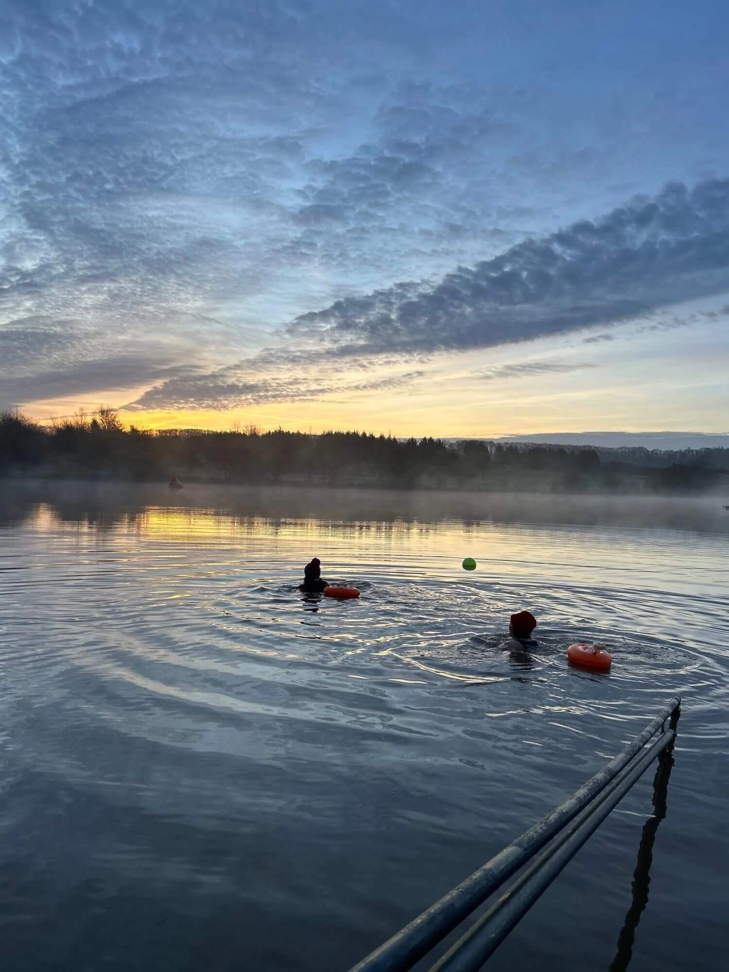 Swimmers in the lake at sunset under a dramatic sky