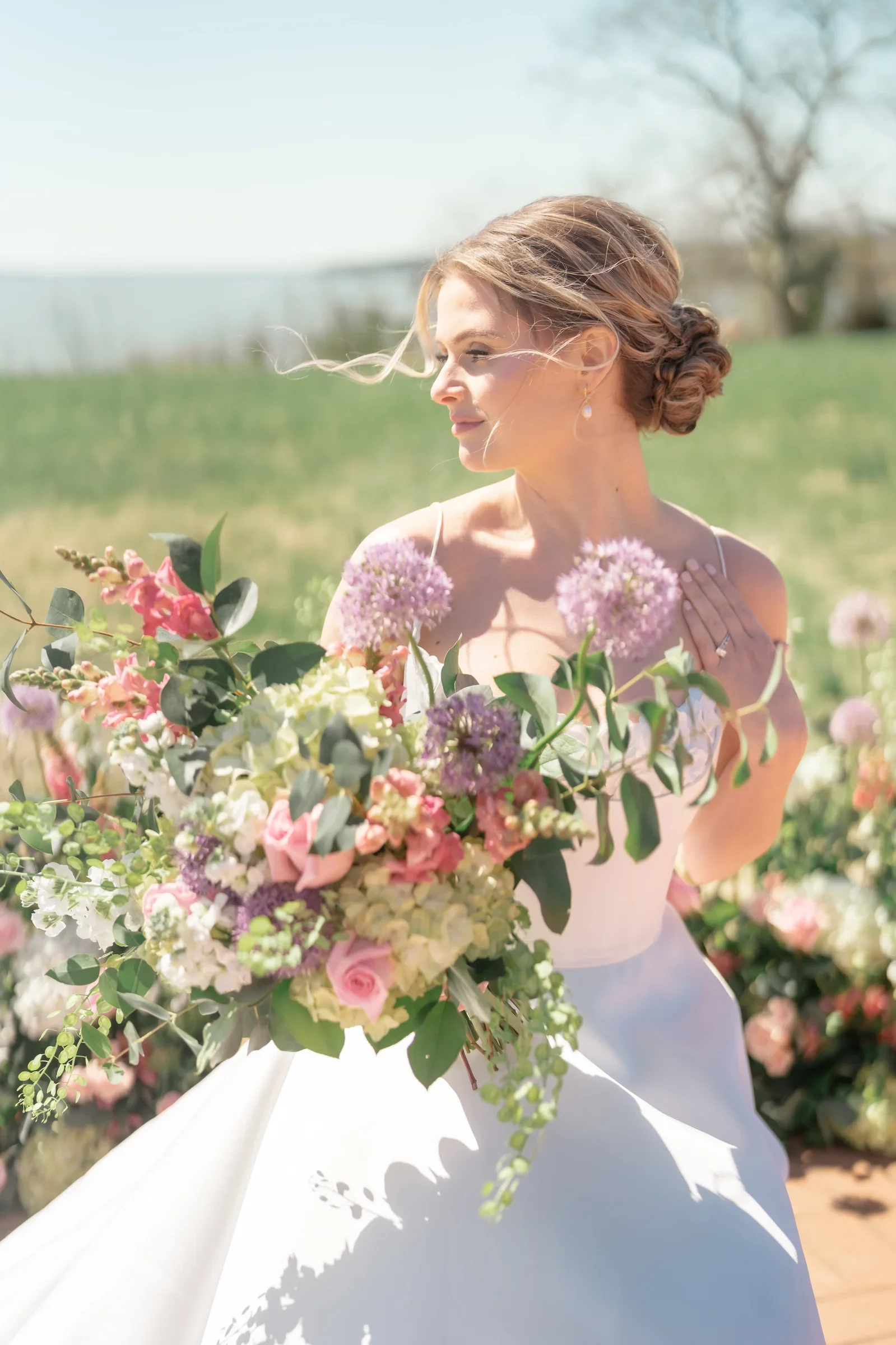 Bride in profile holding a purple bouquet