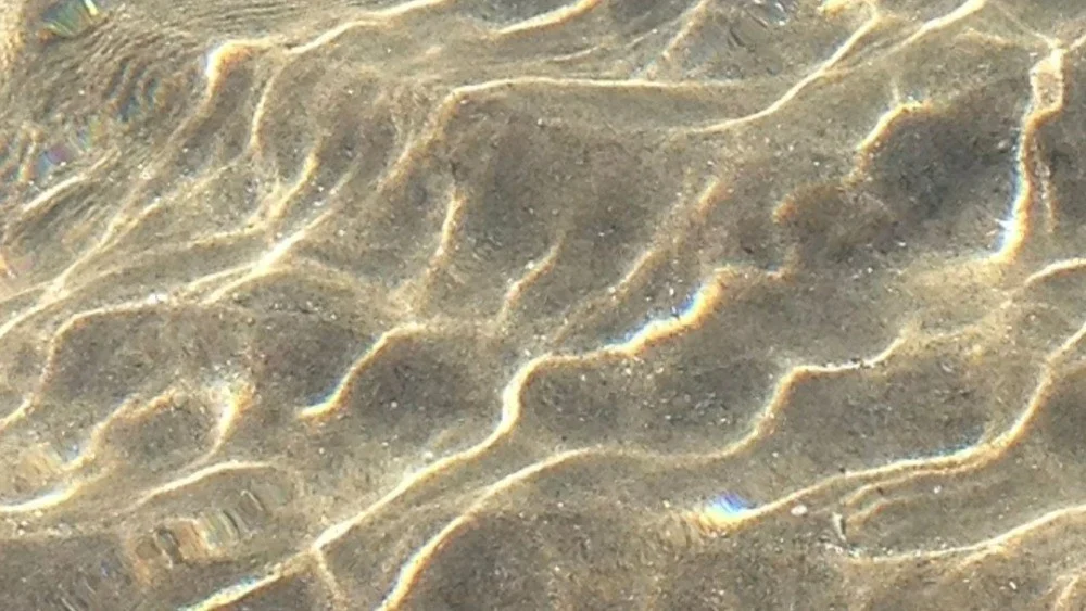 Sunlight moving across shallow sand