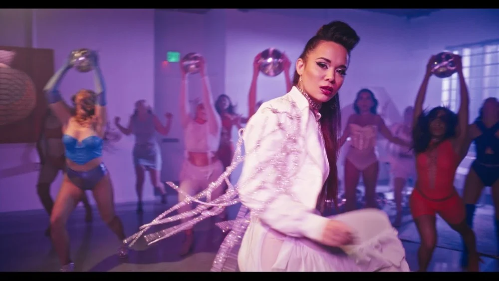 Oriel performing in white in the Freedom music video