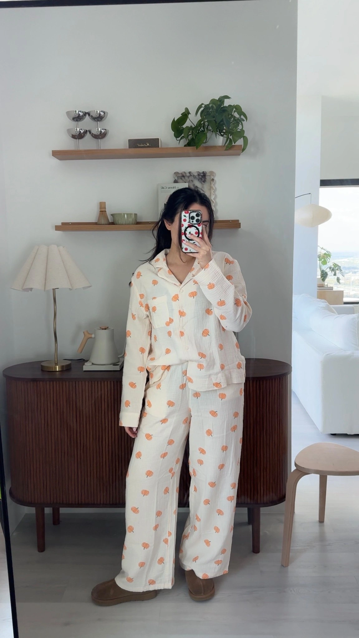 Arabella in pumpkin-print pajamas taking a mirror selfie