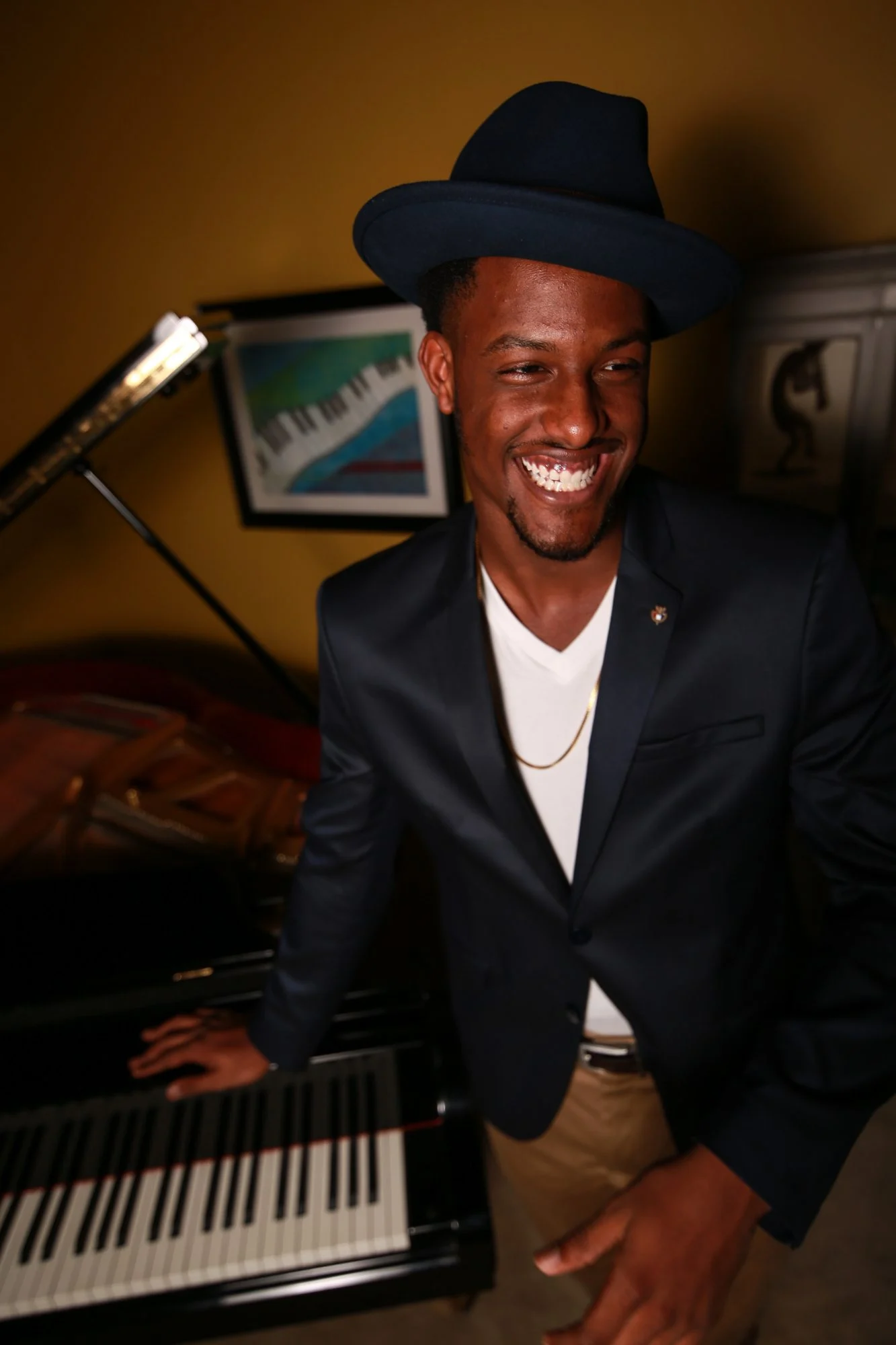 Chops in a hat smiling at the piano