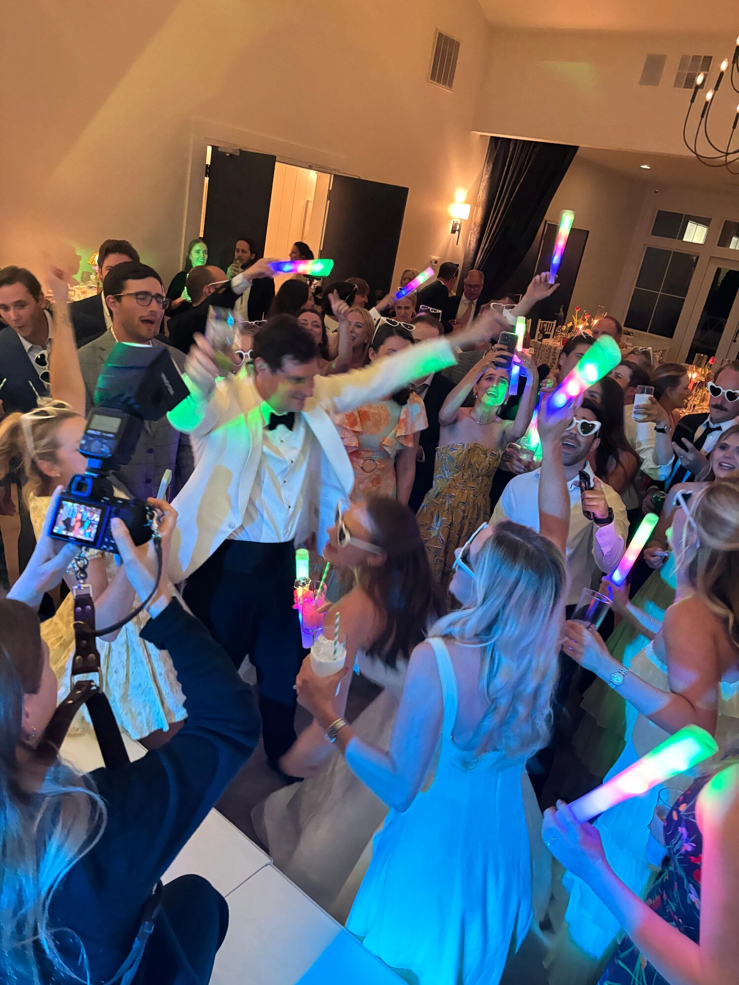 Packed wedding dance floor with glow sticks