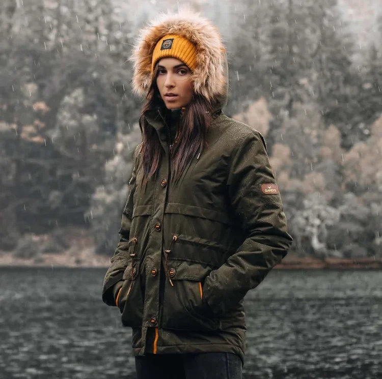 Outdoor lifestyle portrait of a woman in a dark jacket and orange beanie