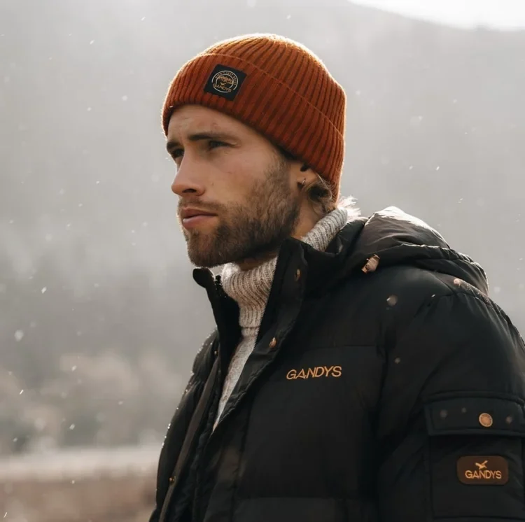 Outdoor lifestyle portrait of a man in an orange beanie and jacket