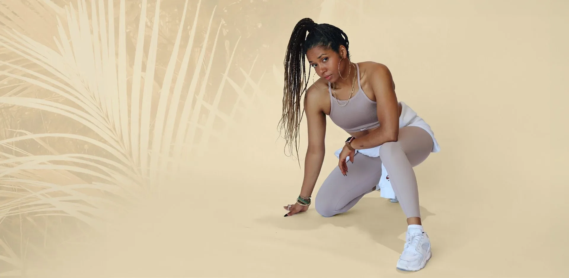 Tashe Smith crouching in a warm beige training studio