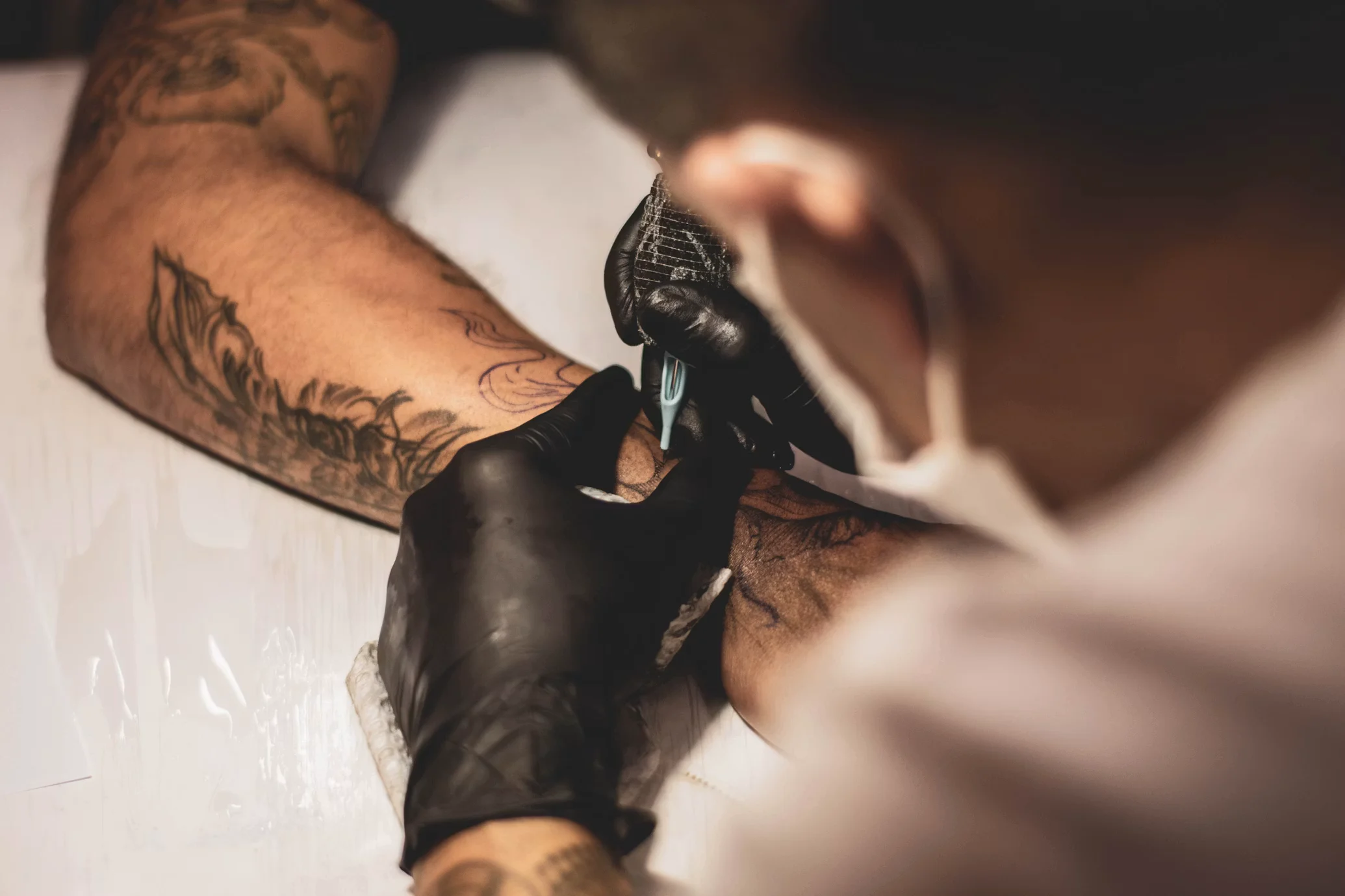Nico preparing a private tattoo station beside a sunlit worktable