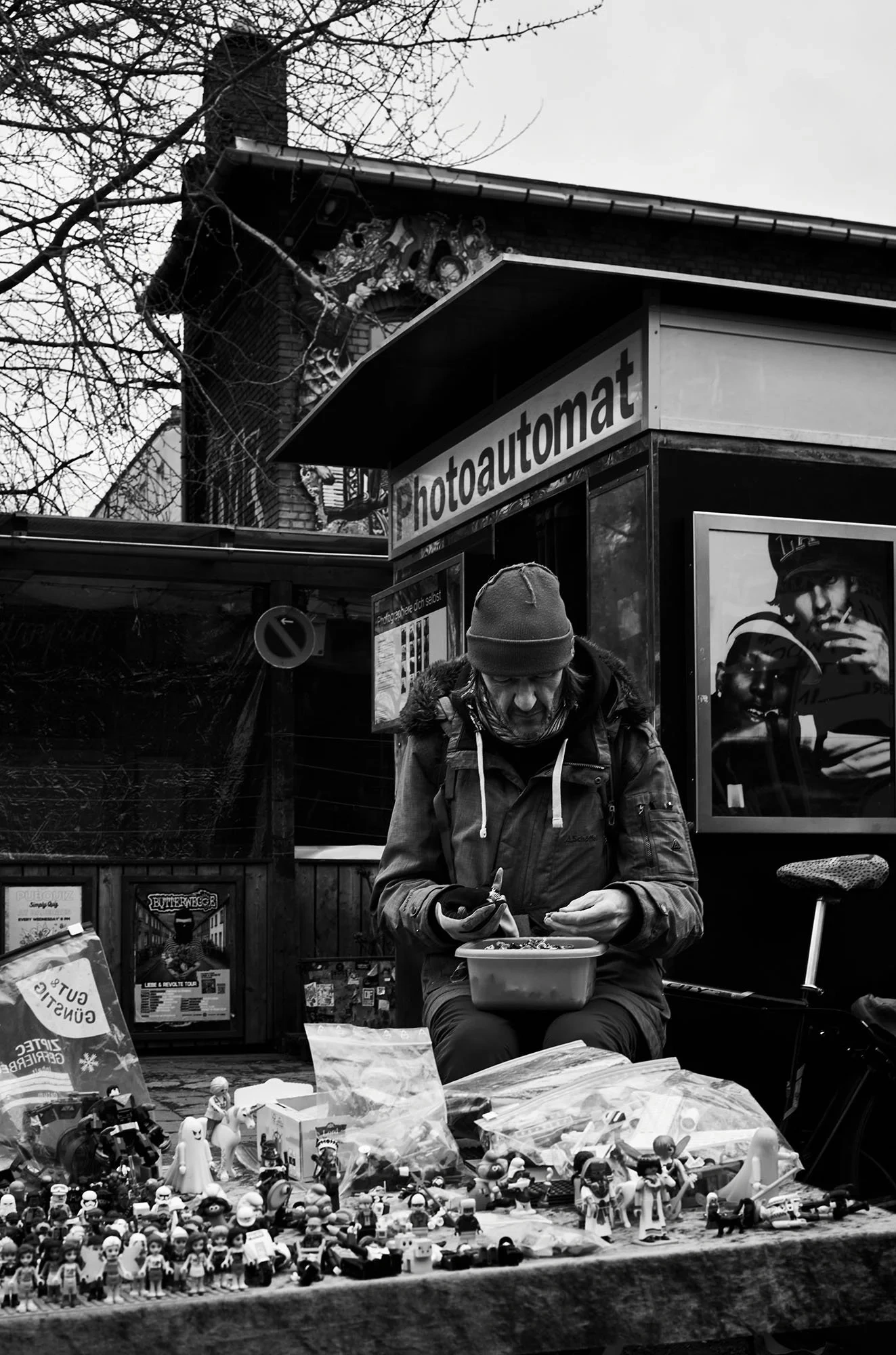 Un venditore al suo banco davanti a una cabina Photoautomat