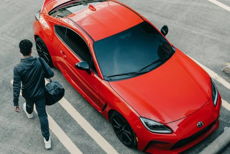 A red Toyota GR86 in a parking lot
