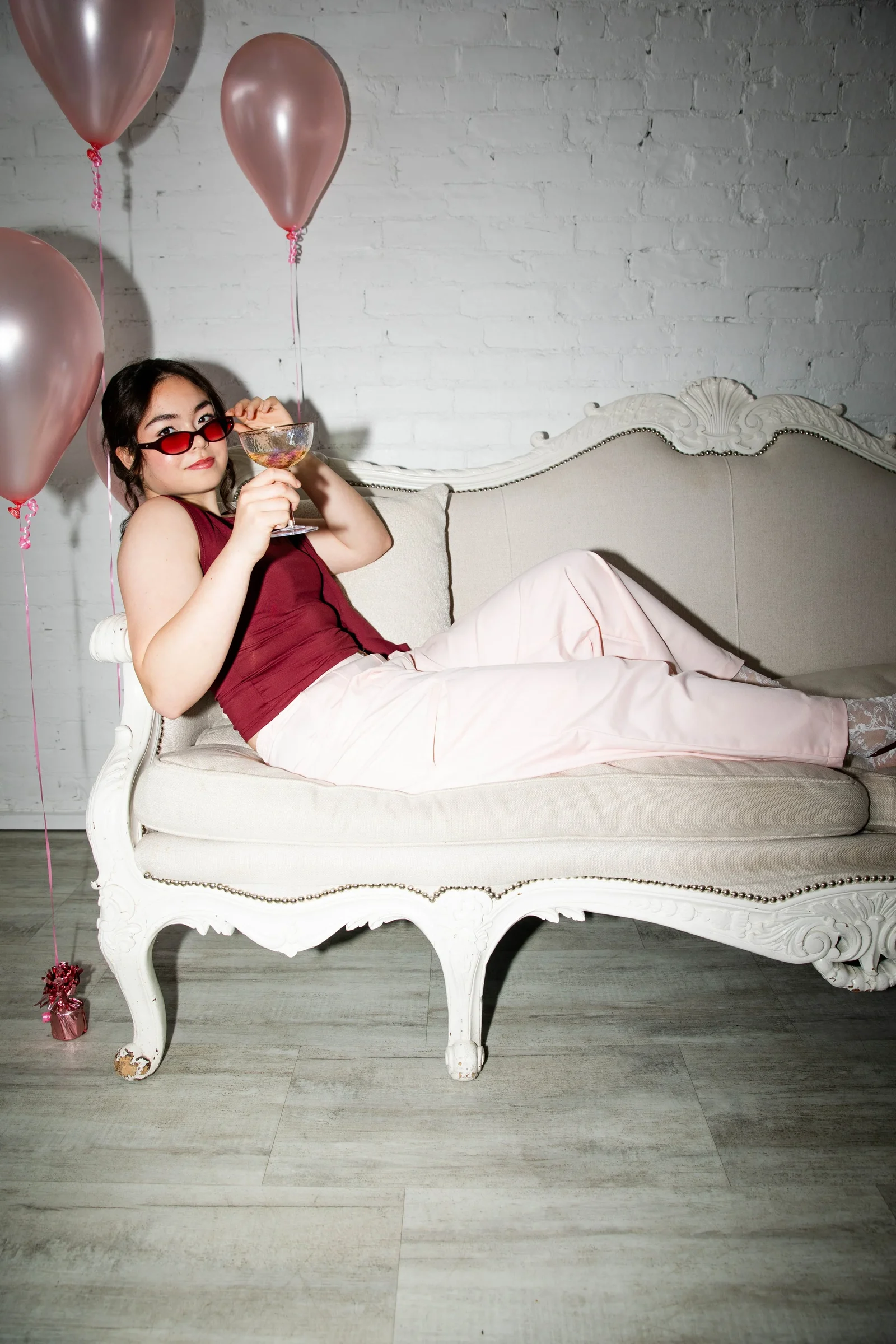 Seated model wearing pink wide leg pants from Love, Emma