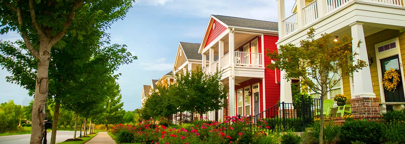 Tree-lined street of colorful Southern homes with porches