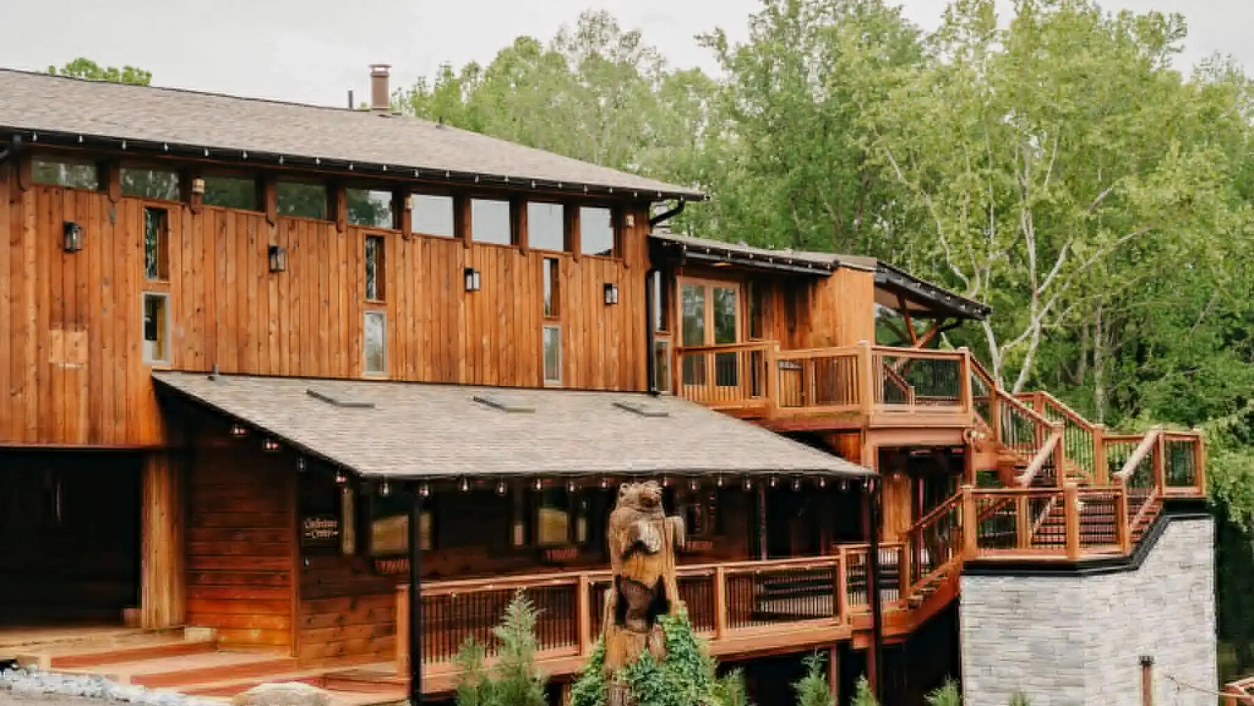 Timber lodge with wraparound decks among trees at Old Mill Village