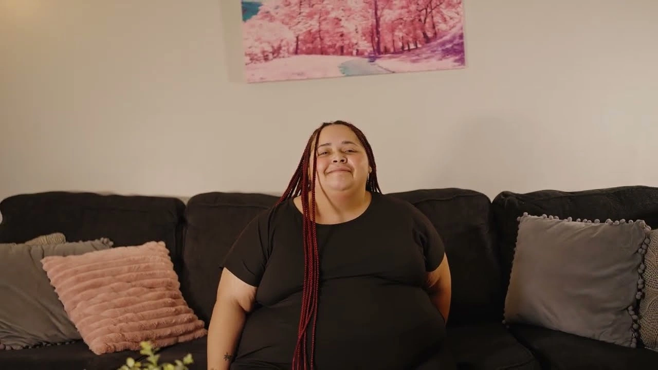 Nadia, a 2026 FreeRent Atlanta Grant recipient, on her couch