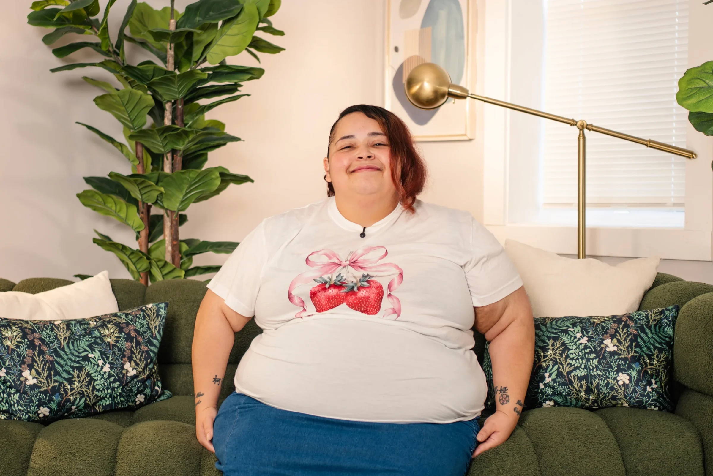 A smiling woman sitting on a green couch at home