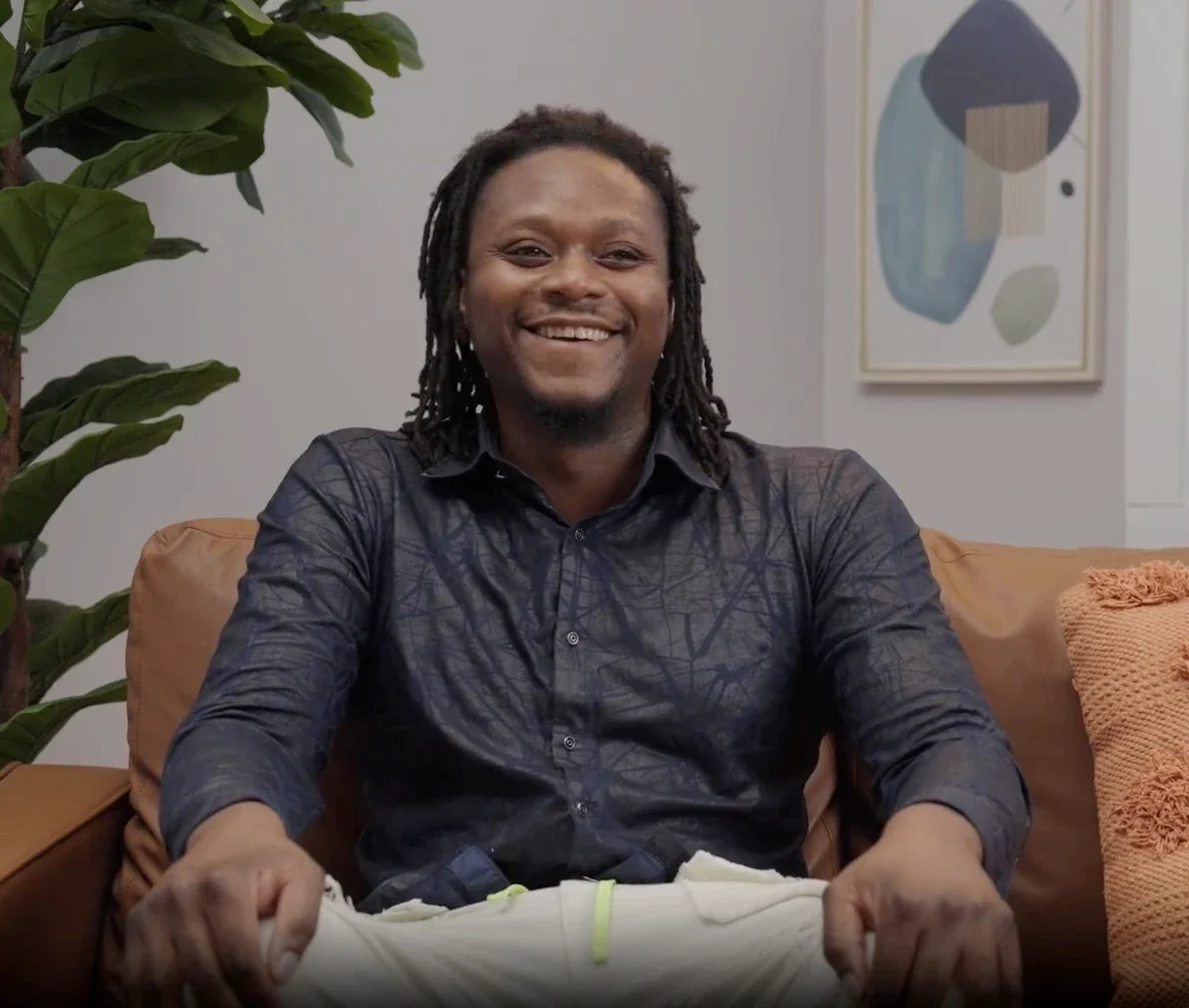 A smiling man sitting on a couch