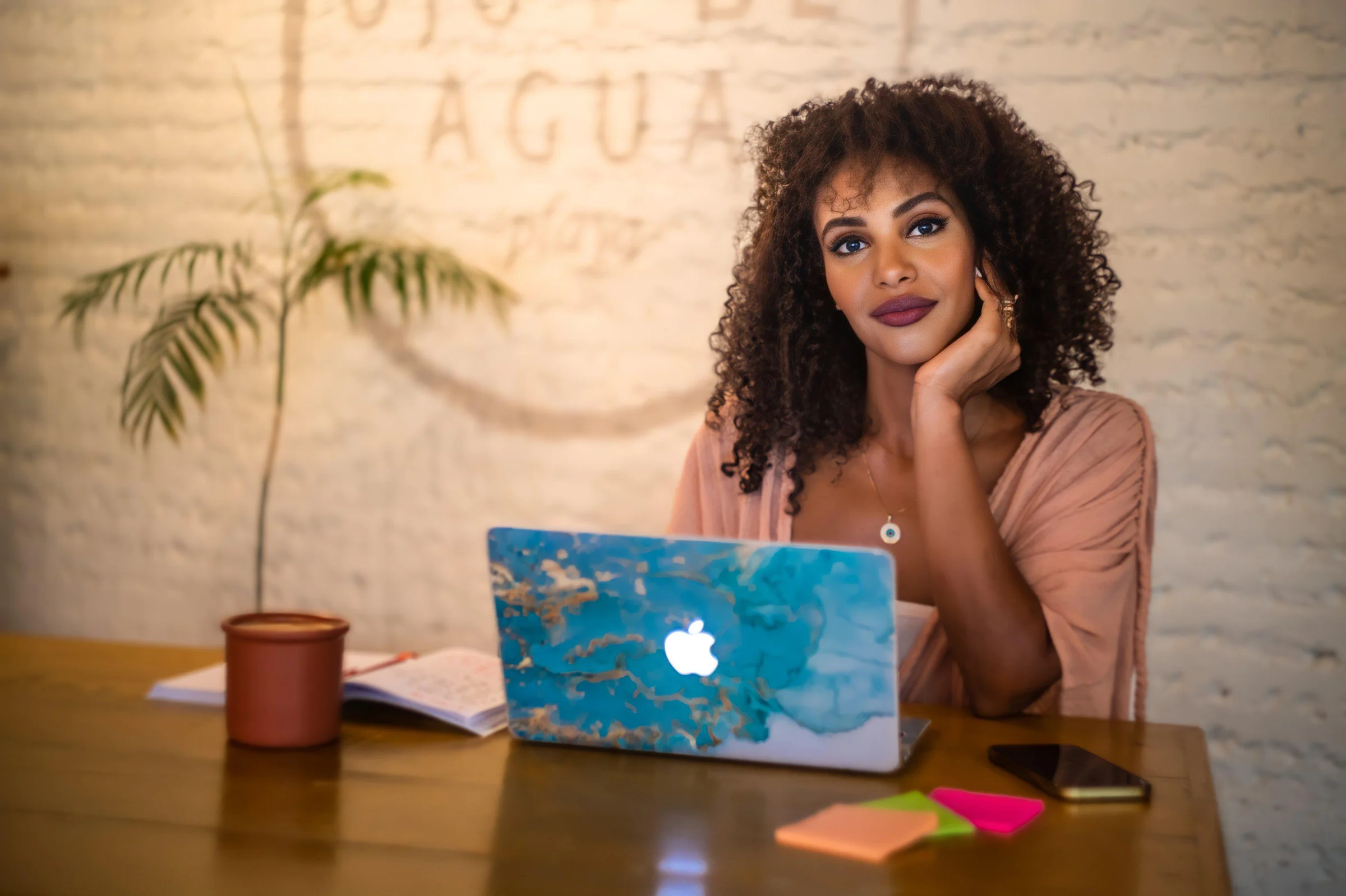 Arwa Ali seated with her laptop at a wooden table