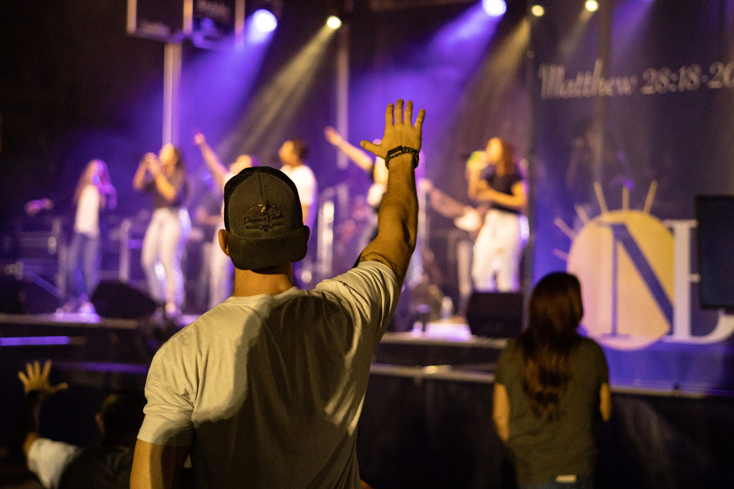 Worship team leading on stage with raised hands