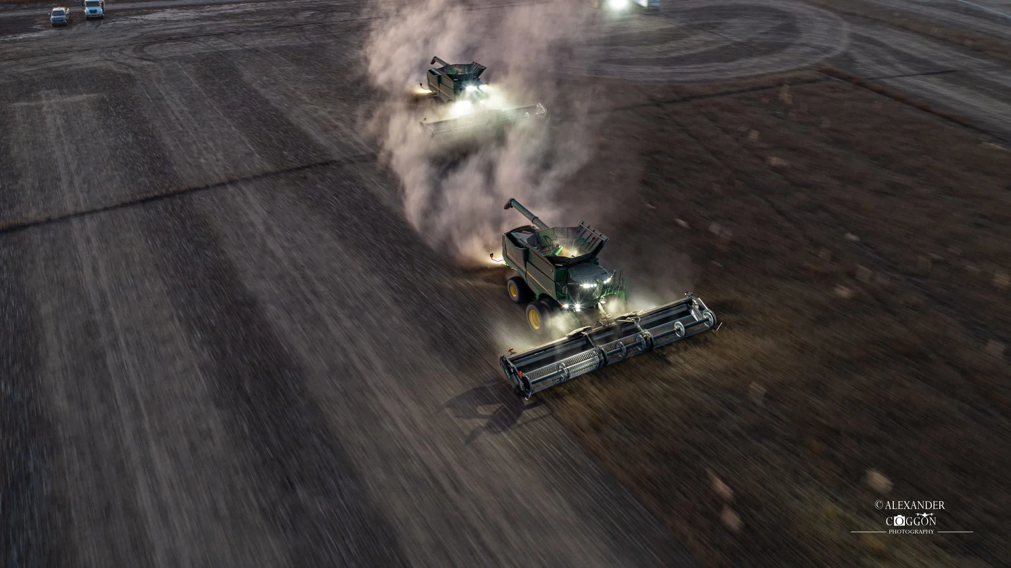 Aerial view of a combine kicking up dust
