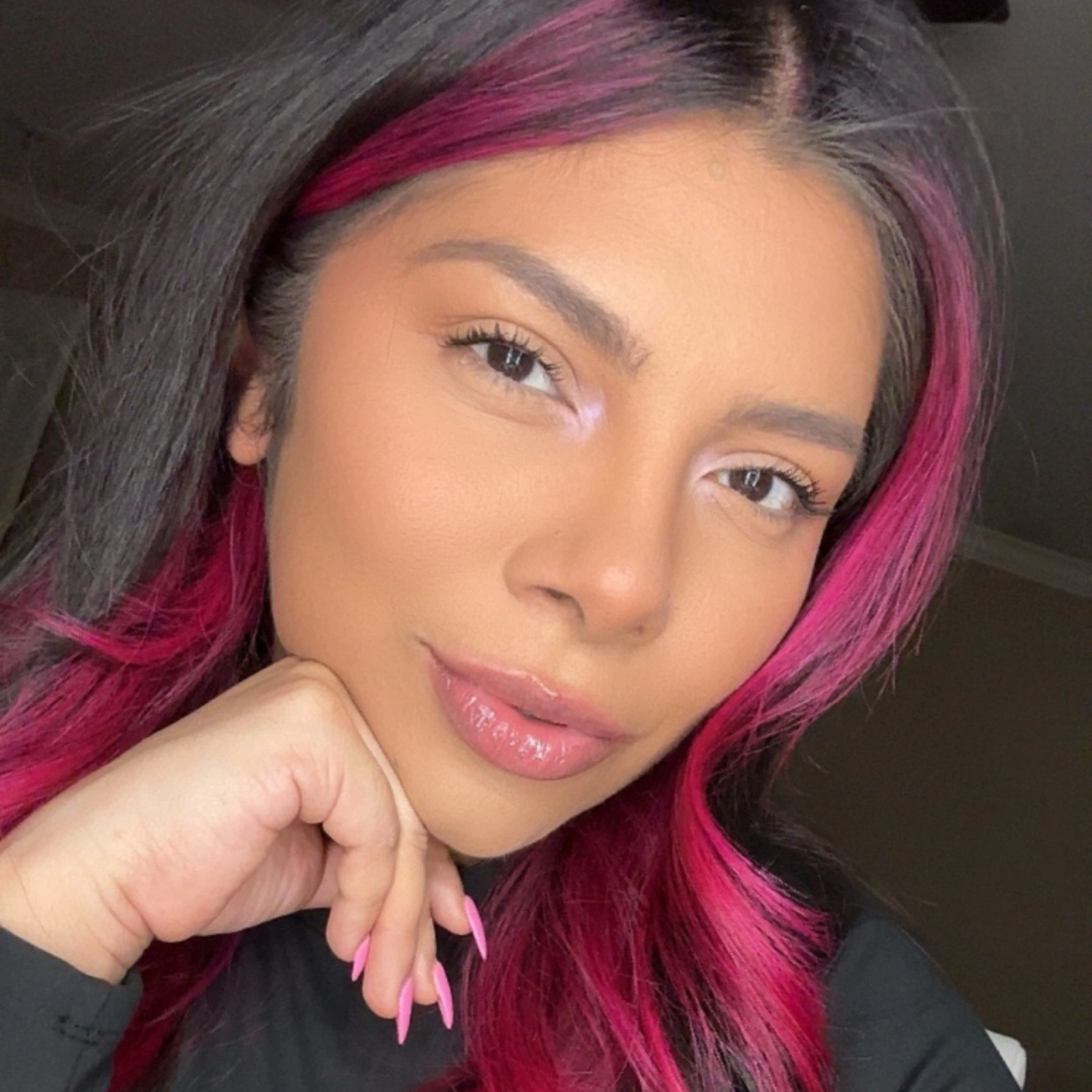 Portrait of Mx. Ram with pink-streaked hair