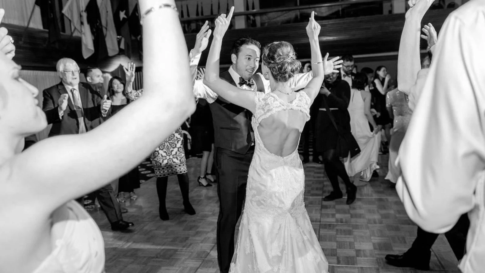 A newlywed couple dancing in a crowded reception
