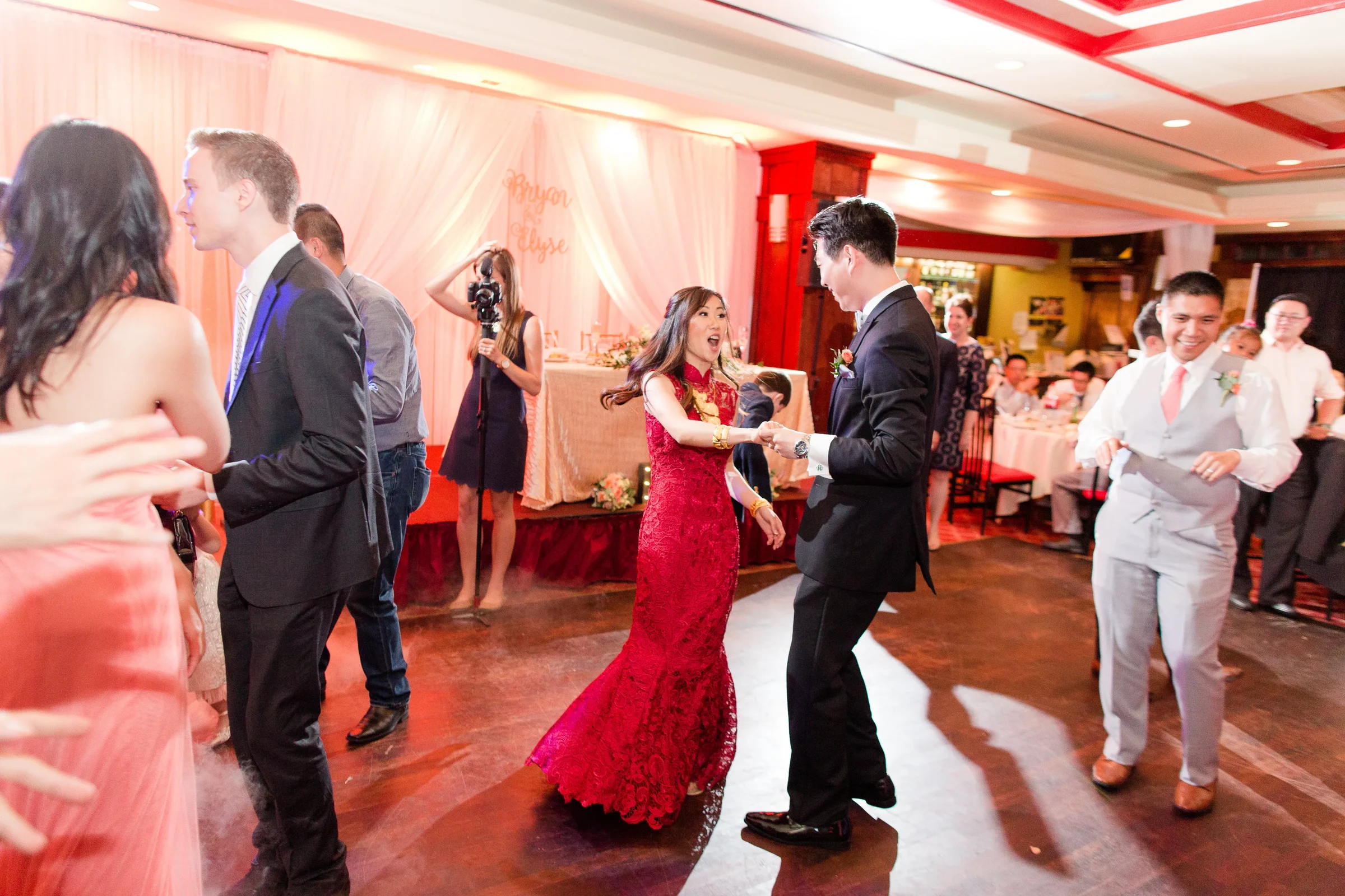 Guests dancing together under warm red light