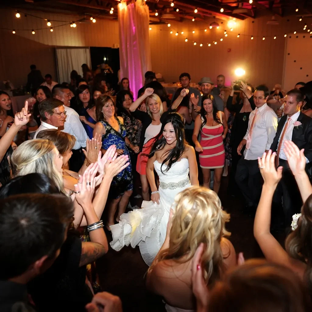 A bride dancing at the center of a crowded reception
