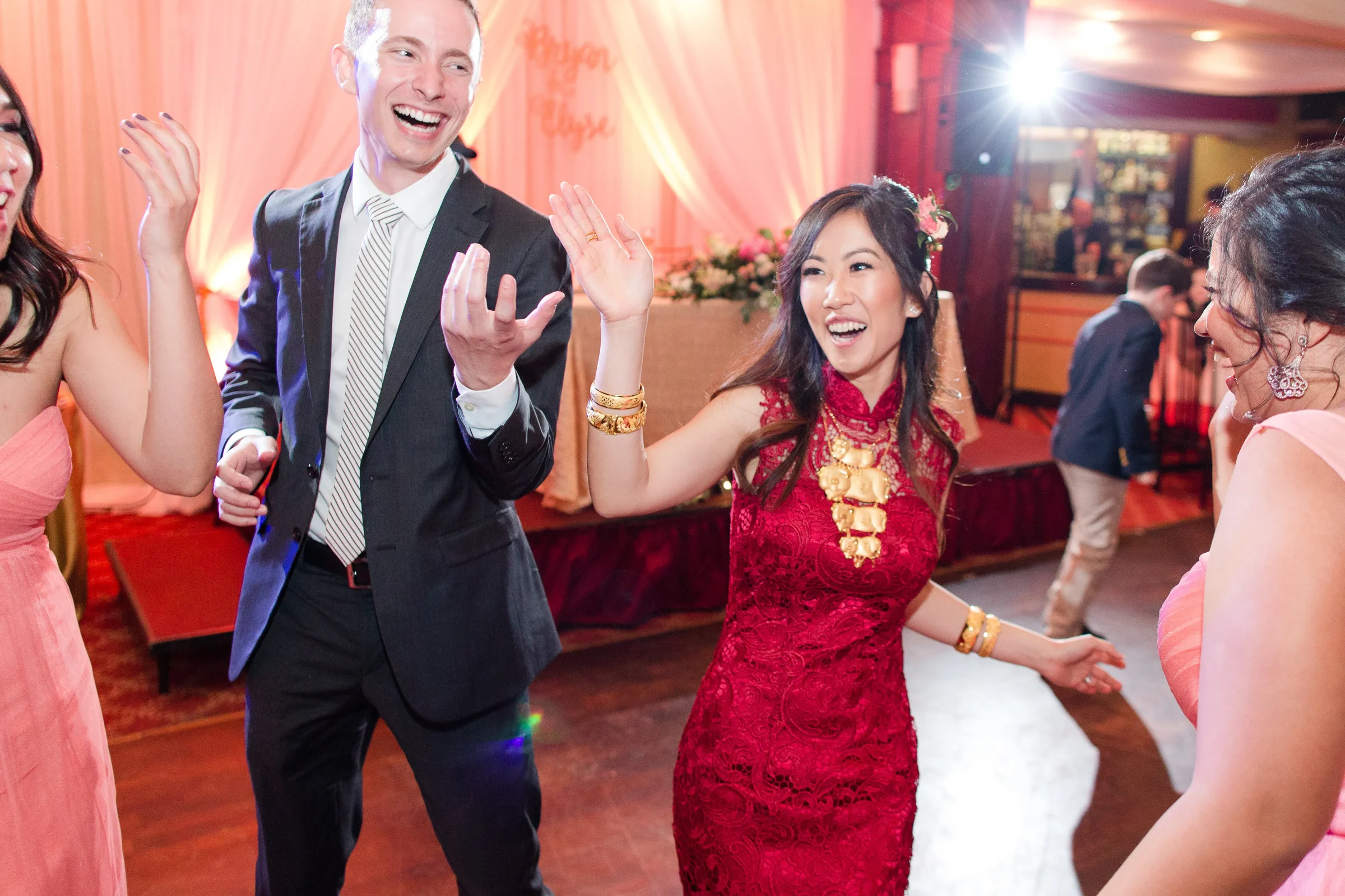 A newlywed couple laughing together while dancing