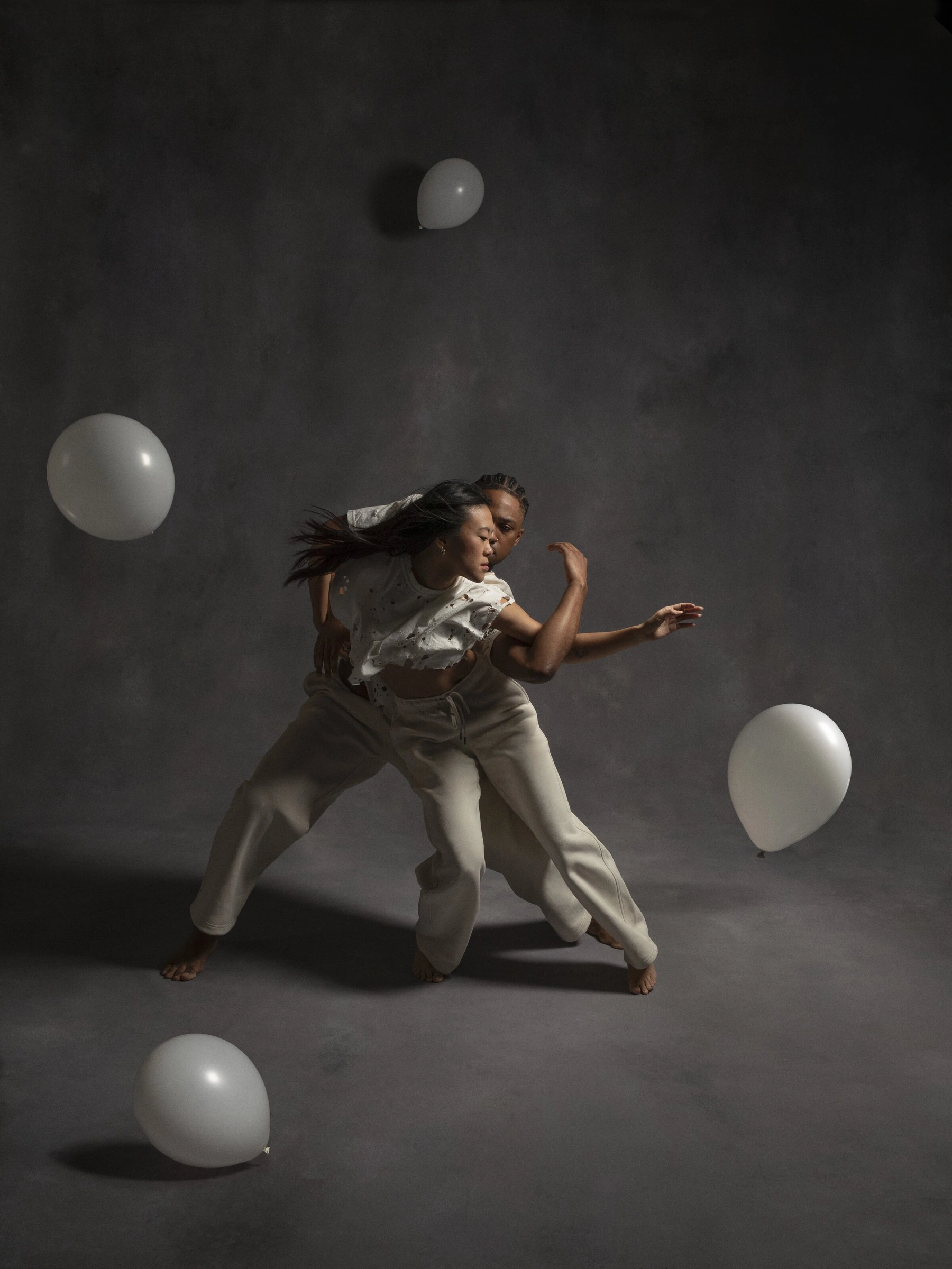 Destin Morisset and Olivia Wang dancing in distressed white clothing among floating white balloons in White Space
