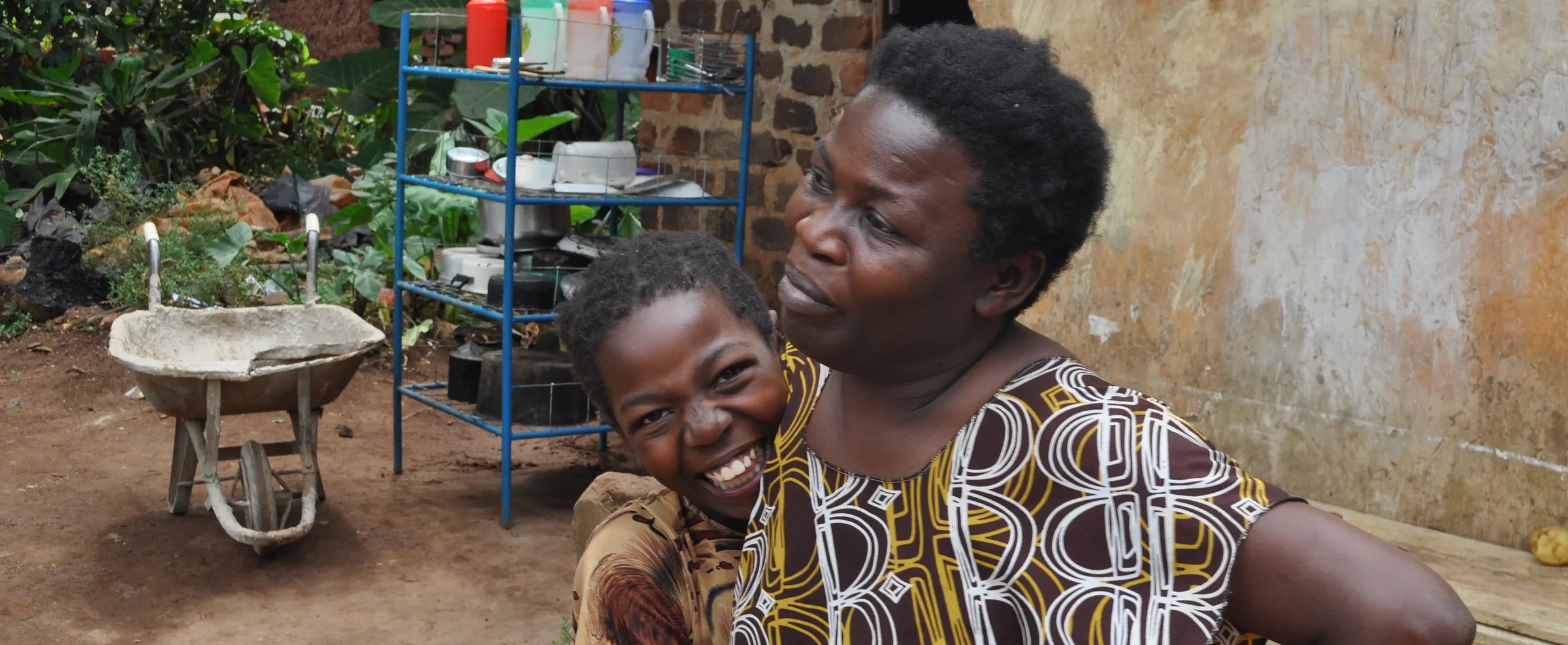 Mother and child beside a clean-water station in Uganda
