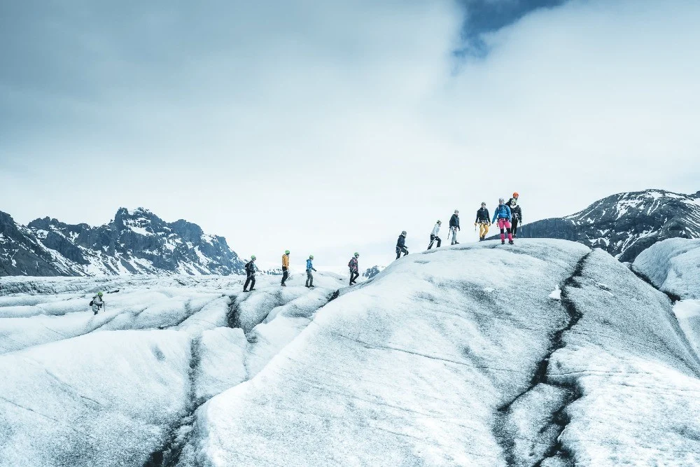 Travelers walking across an Icelandic glacier