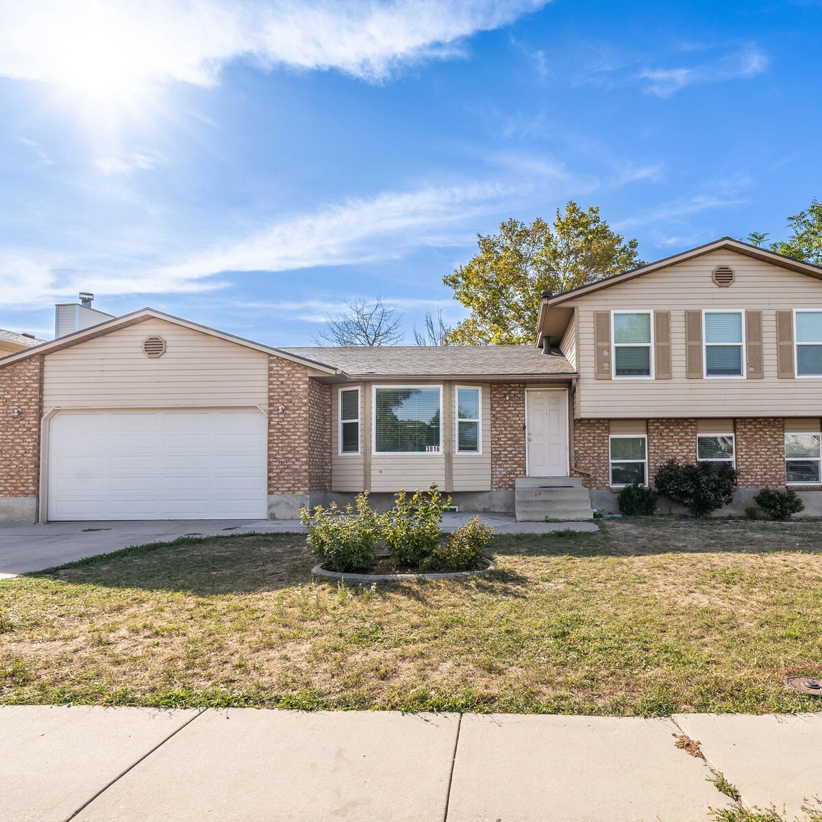 Brick tri-level home with a two-car garage at 3816 S Pheasant Glen Dr, West Valley City