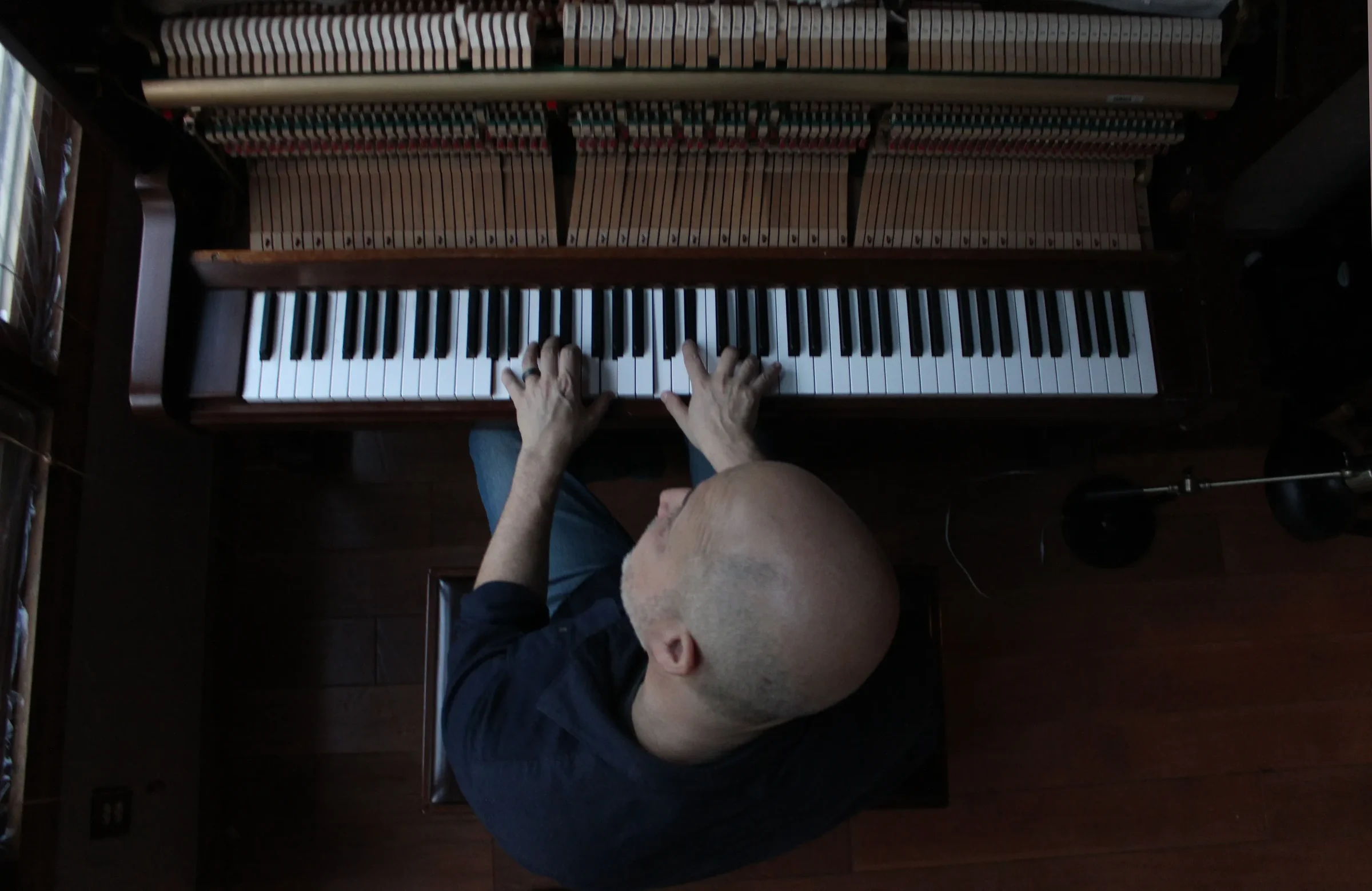 Overhead view of Rick Gallagher playing an open upright piano