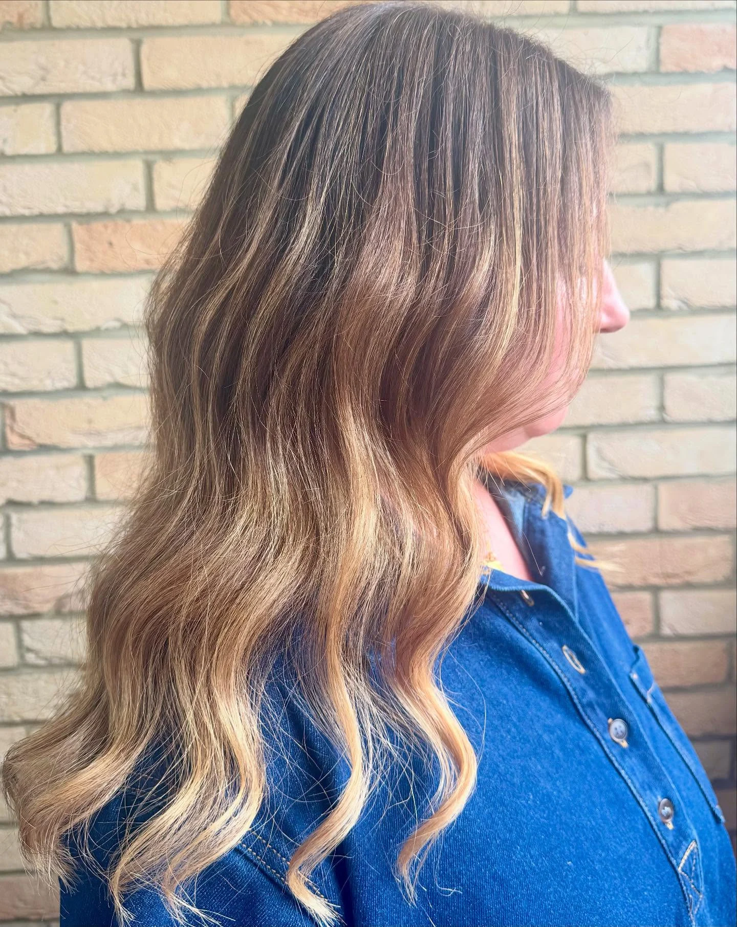 Long brunette hair with warm blonde balayage and soft waves