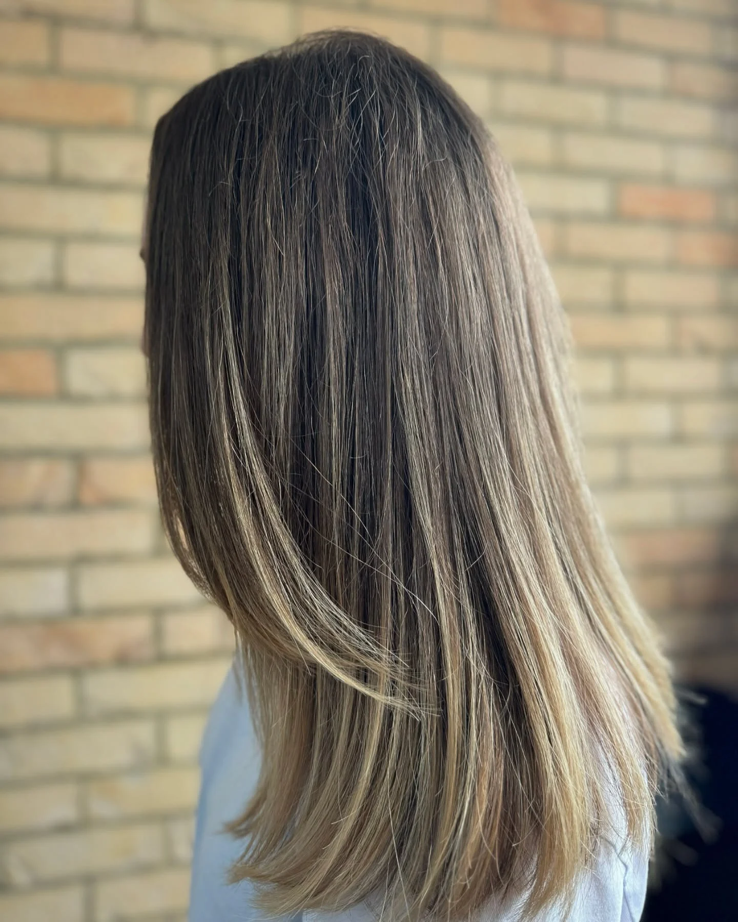 Long straight brunette hair with fine blonde ribbons and softly blended ends