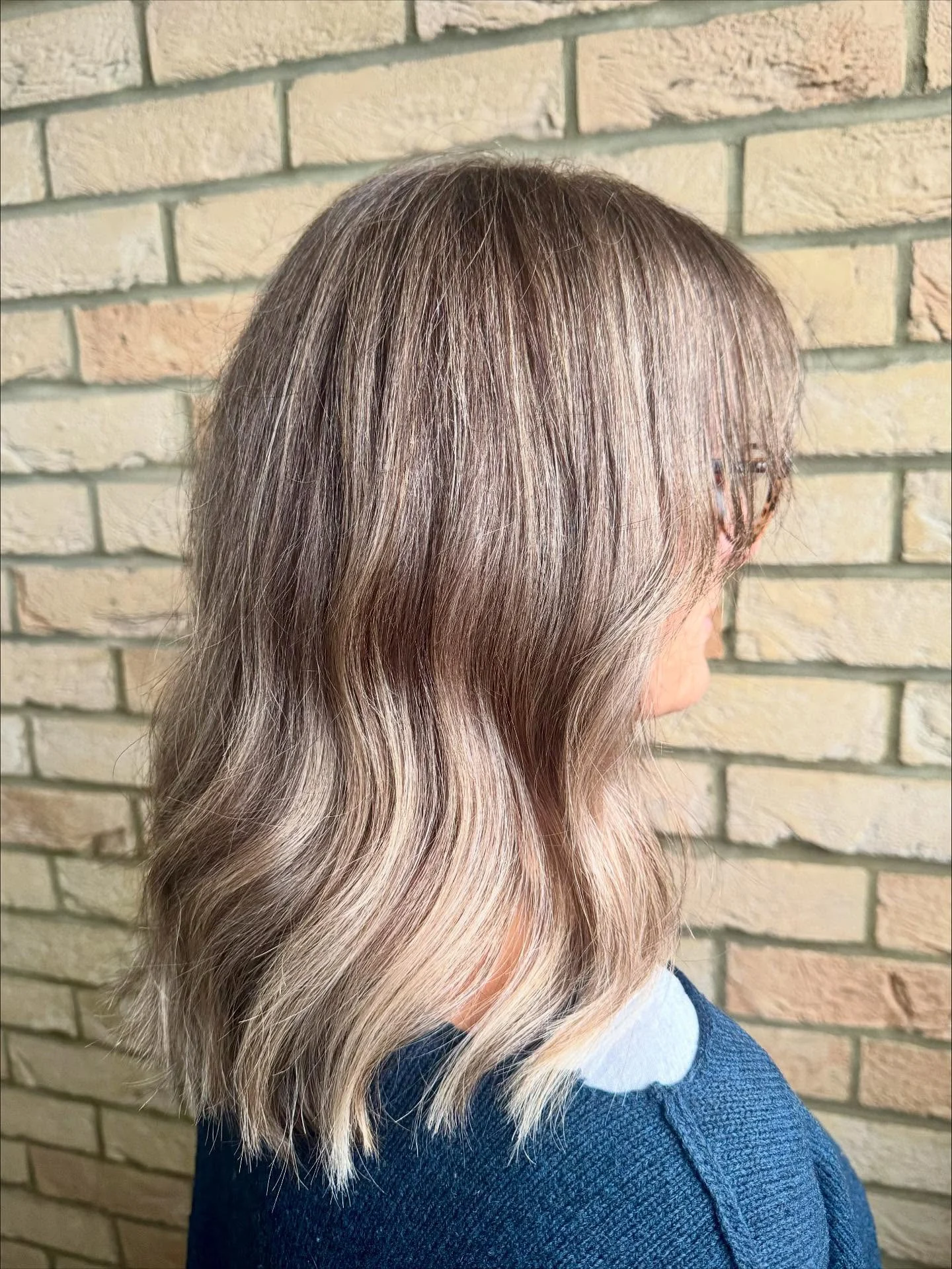 Shoulder-length brunette hair with soft beige highlights and a glossy finish