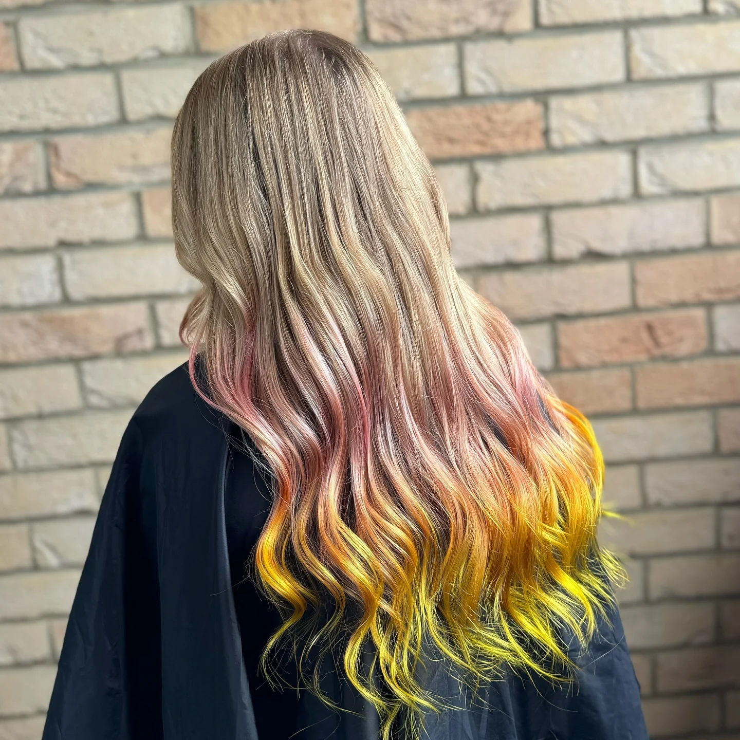 Long wavy hair with a soft pink midsection and vivid yellow ends