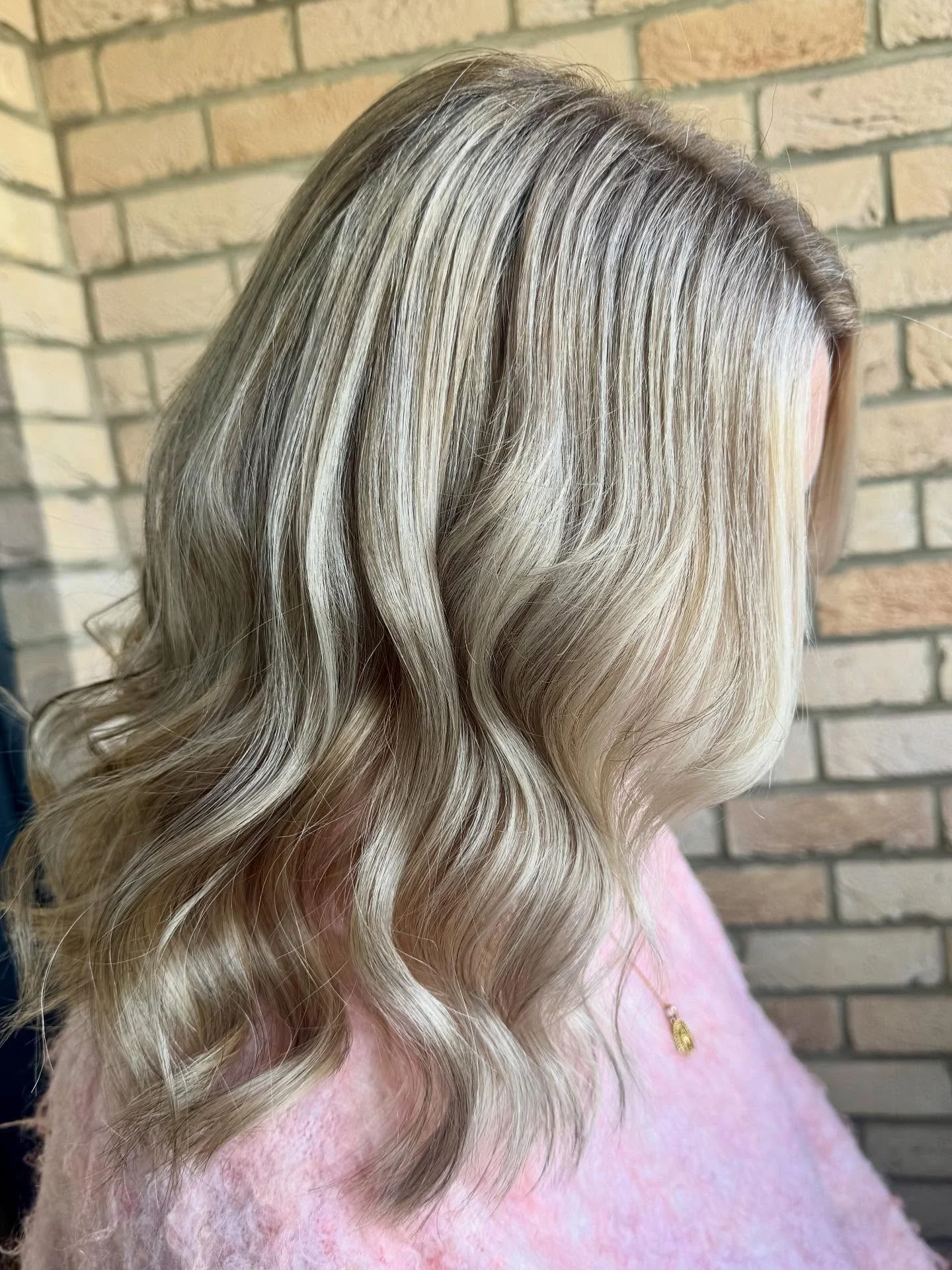 Soft blonde hair with cool highlights, natural depth, and loose waves