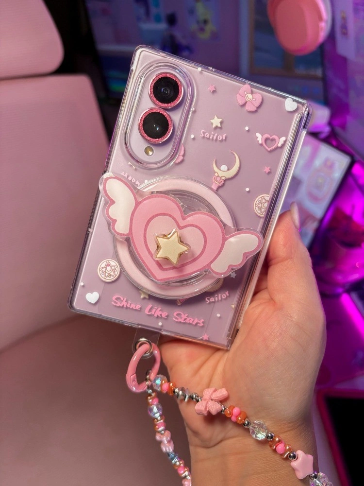 Galaxy Z Fold 8 in a lilac case with a pink winged heart grip and a beaded charm