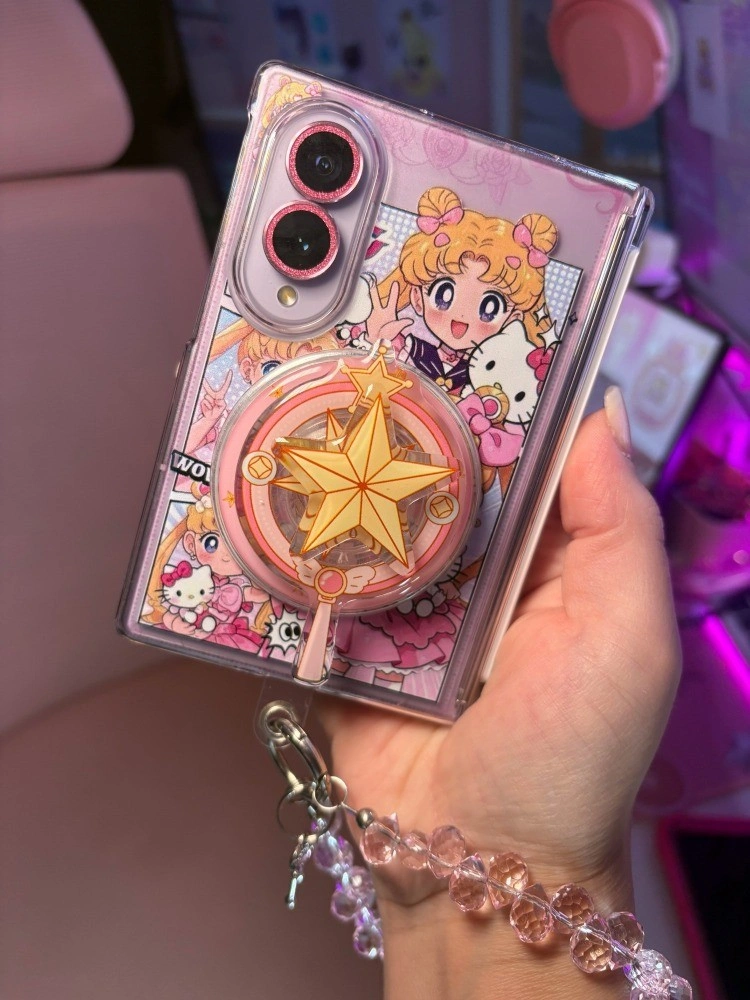 Galaxy Z Fold 8 with a Sailor Moon and Hello Kitty case and a gold star wand grip