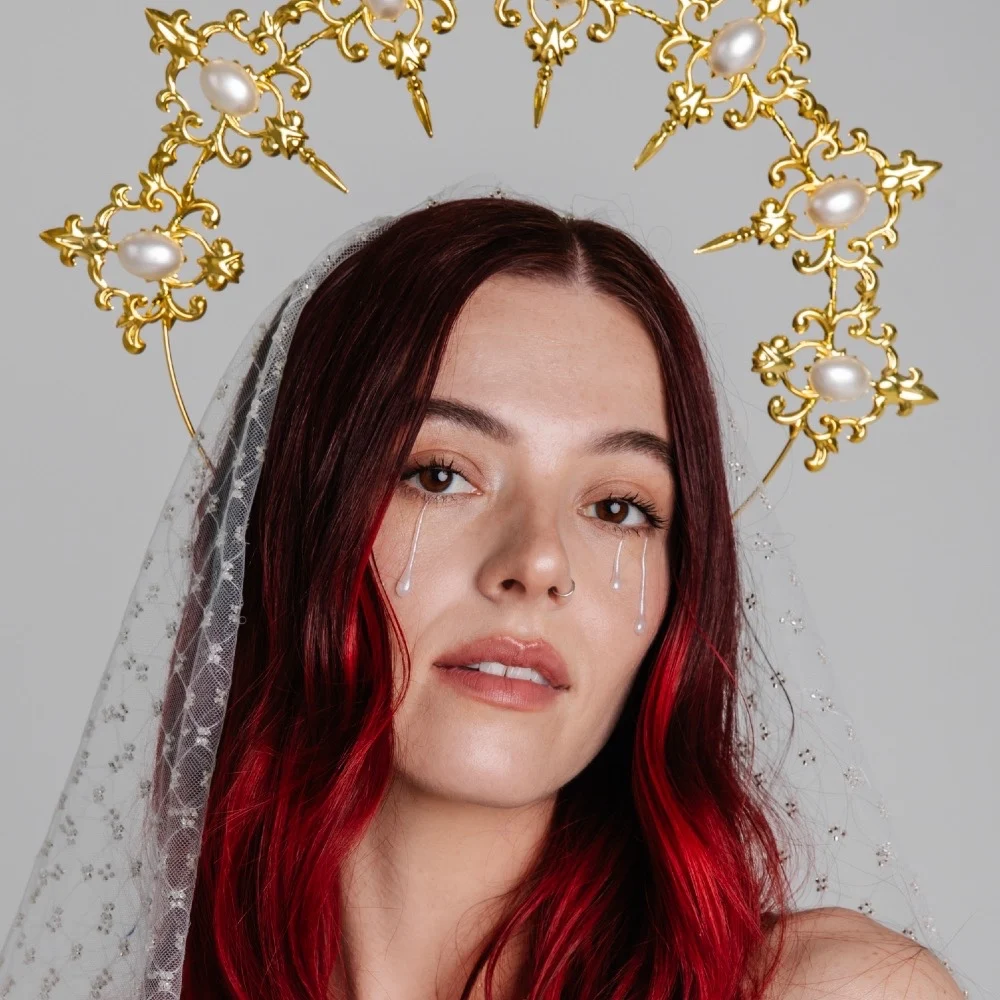 Portrait of Piper Nelson wearing a gold pearl headpiece and delicate veil