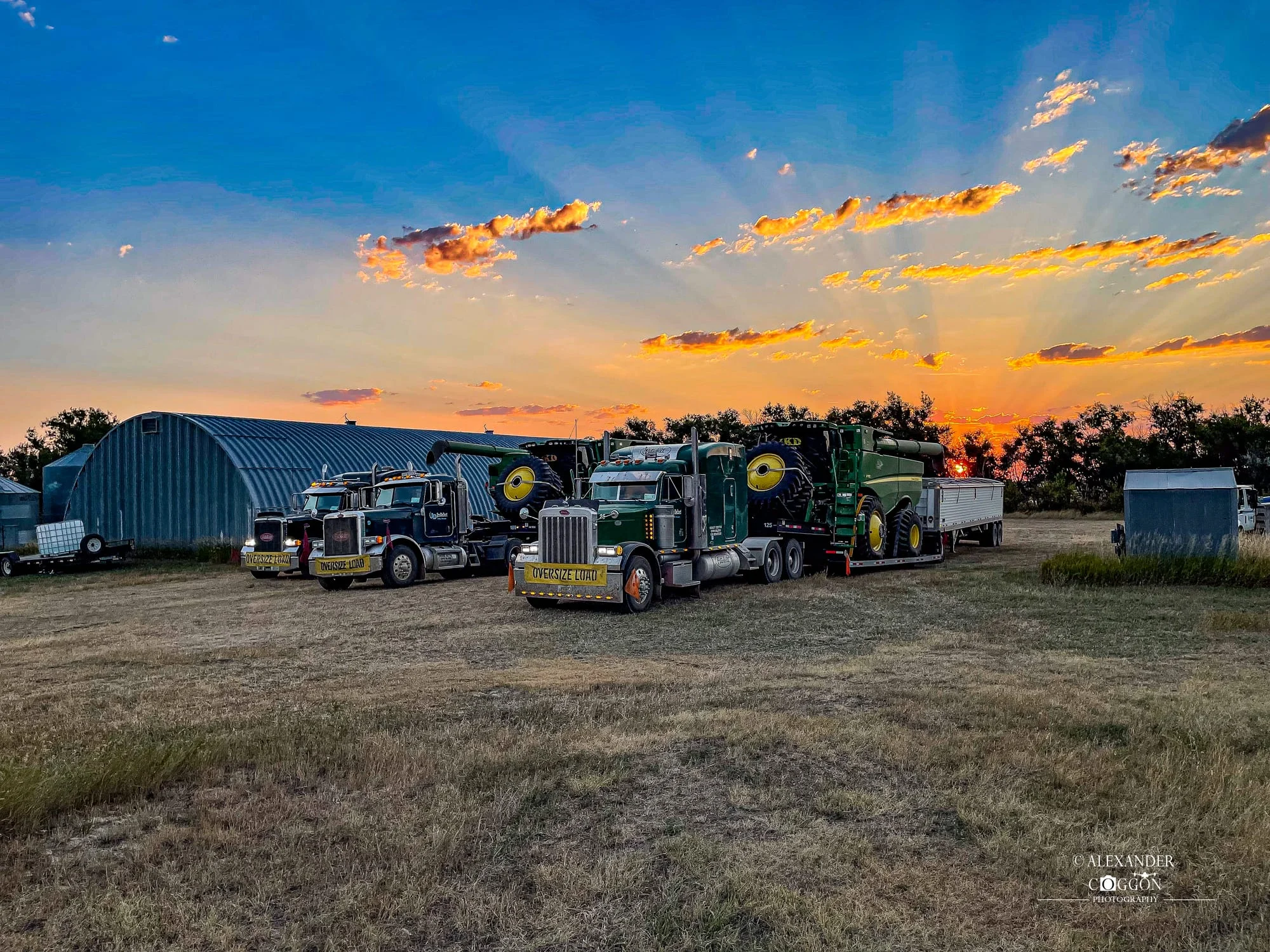 US custom harvest crew trucks and combines at sunset