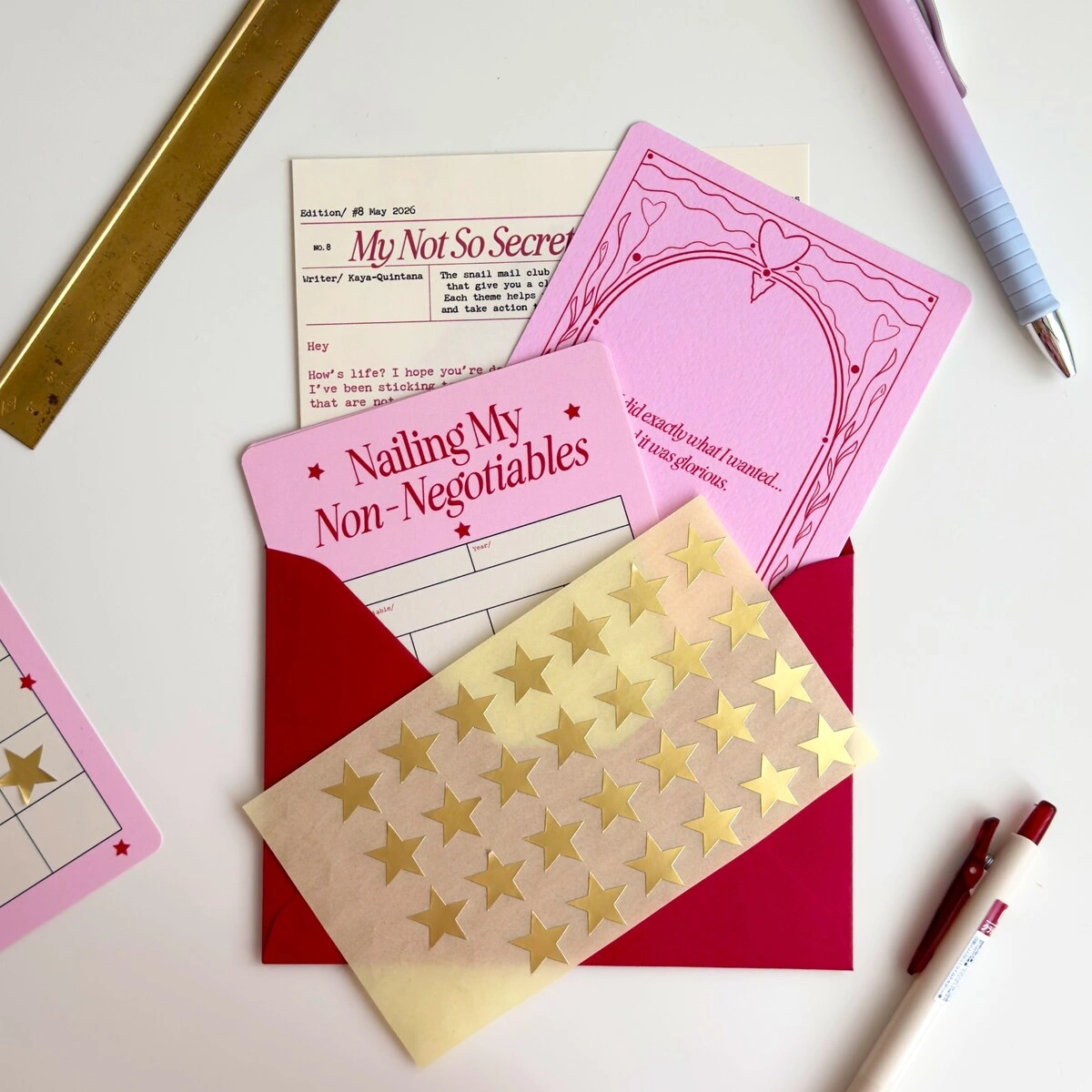 May snail mail letter with pink prompt cards and gold star stickers in a red envelope