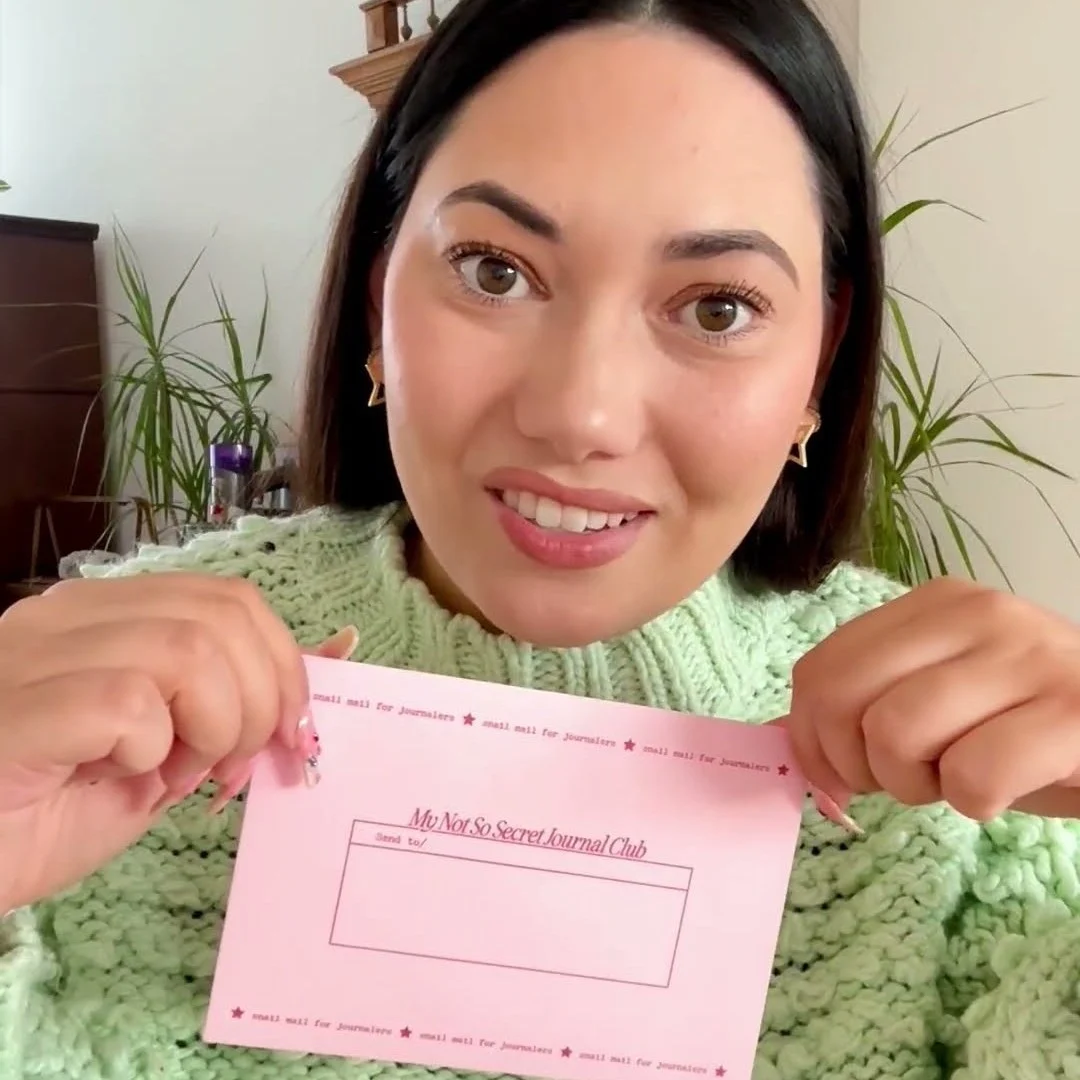 Kaya-Quintana holding up a pink My Not So Secret Journal Club envelope