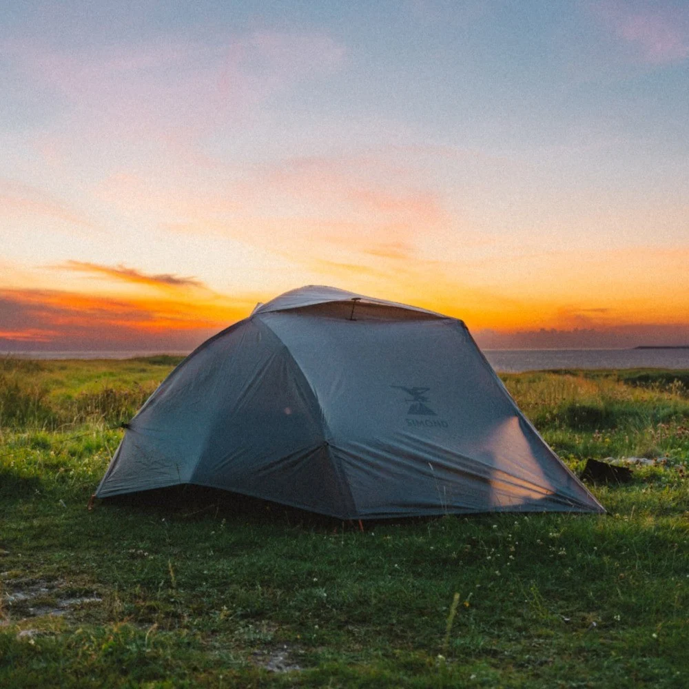 A tent pitched beneath a pastel sunset